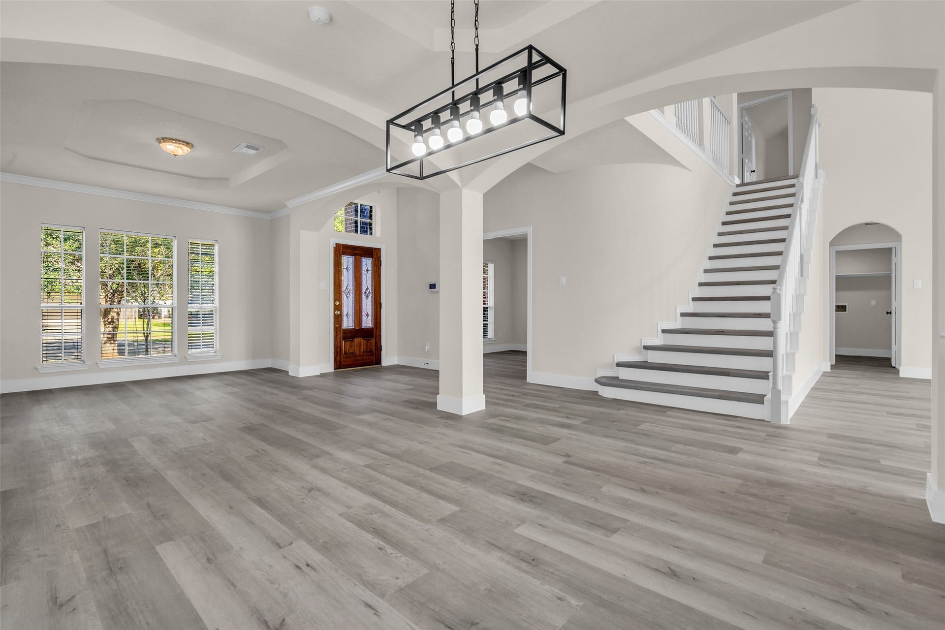 6110 Four River Drive, Richmond, TX 77469 Spacious open-plan dining room with elegant hardwood floors and abundant natural light features a grand staircase leading to the upper level.
