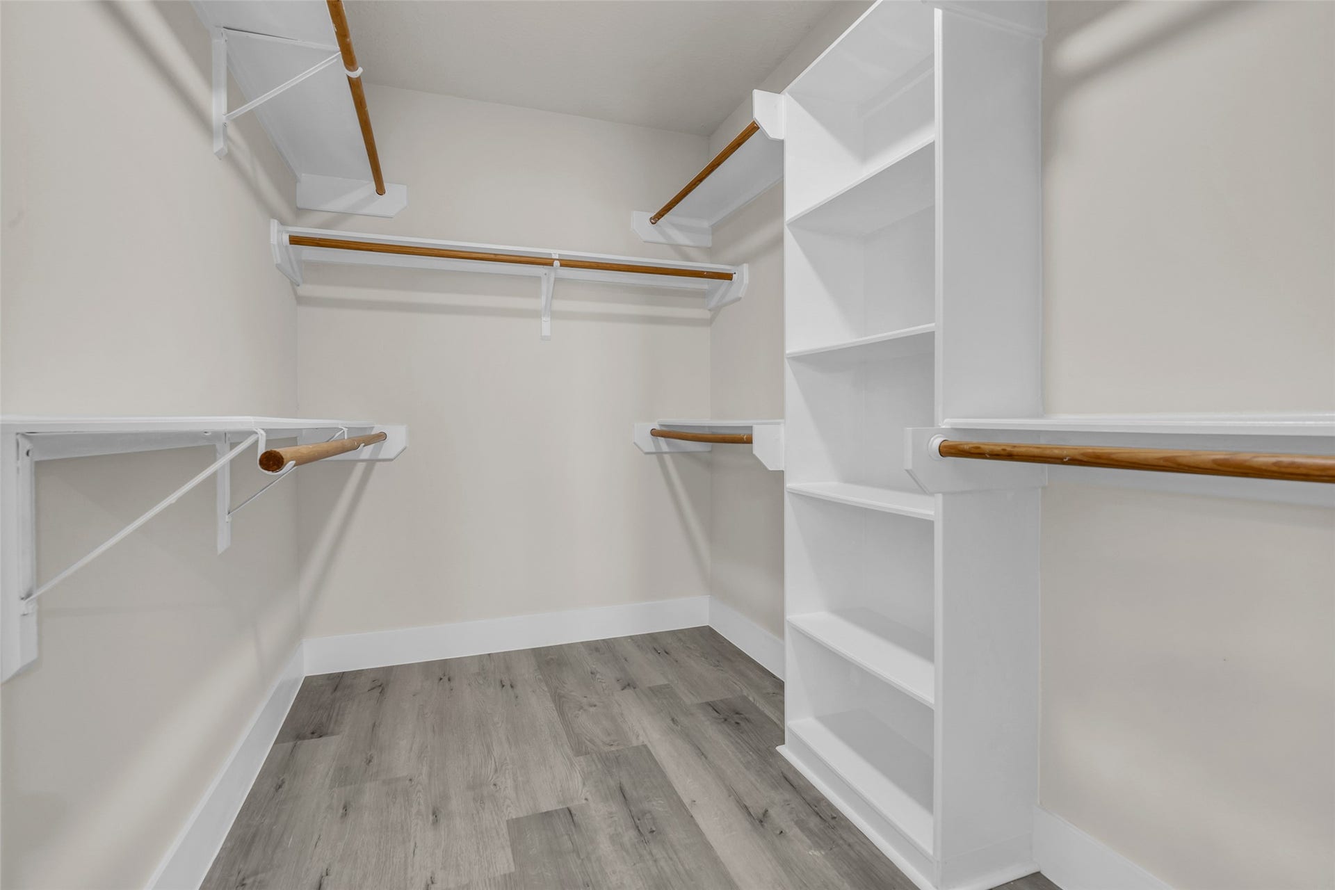 6110 Four River Drive, Richmond, TX 77469 Spacious walk-in closet featuring multiple hanging rods and built-in shelving for optimal organization.