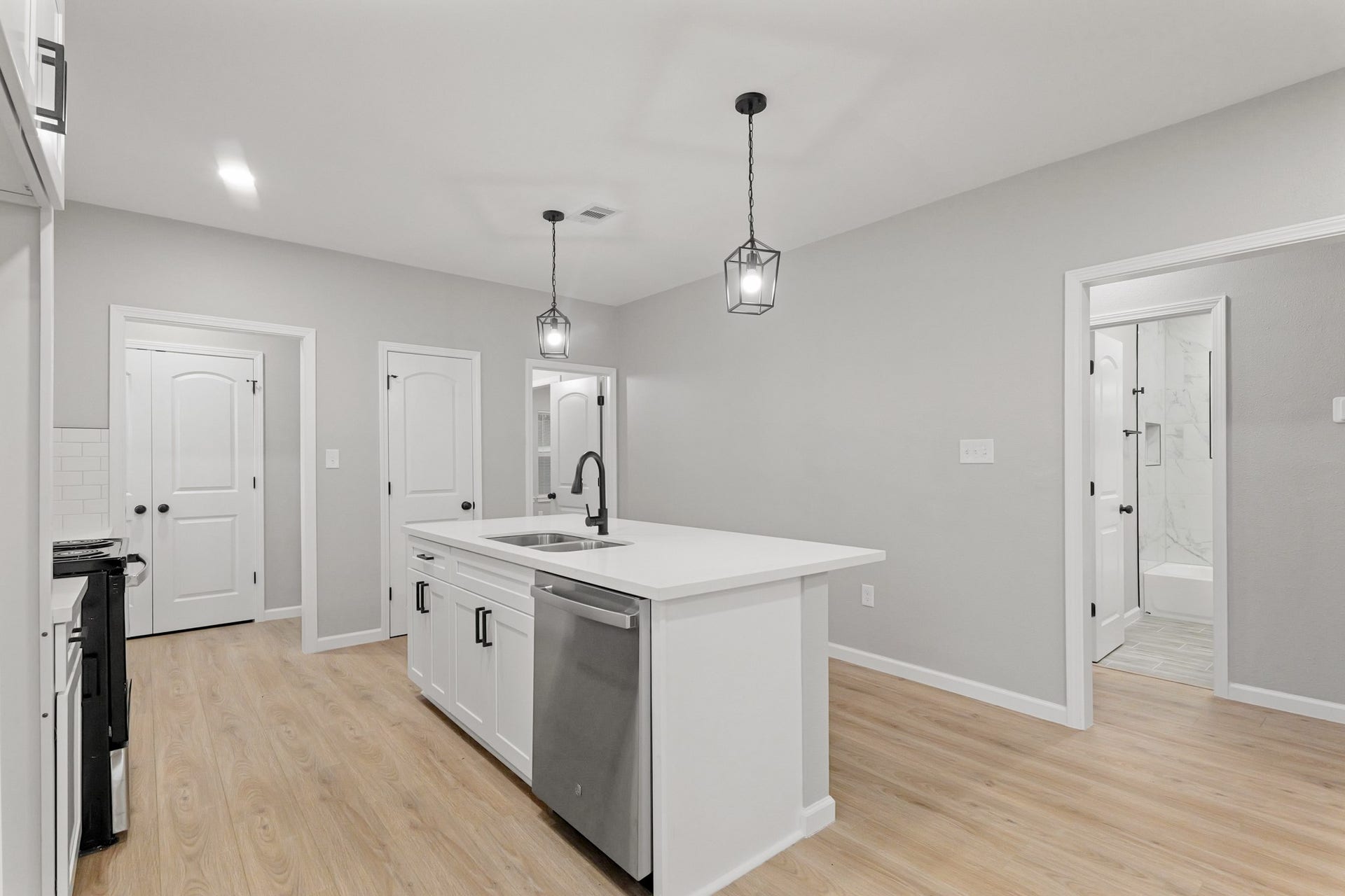 The sprawling island with breakfast bar seating serves as a versatile centerpiece, providing additional workspace, storage, and seating for casual dining or entertaining.