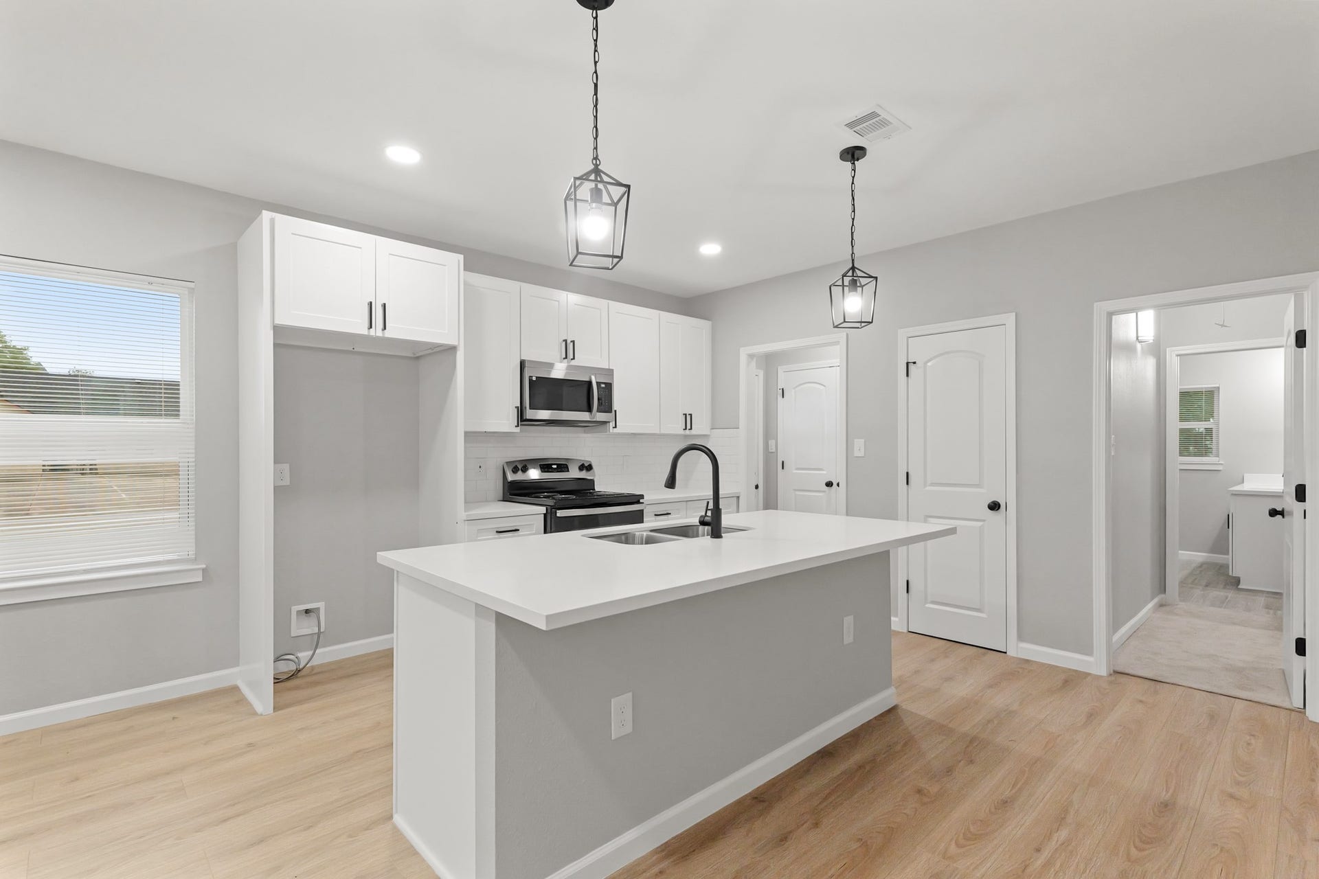 Your chef inspired kitchen awaits! Features include granite countertops paired with a coordinating backsplash, stainless steel appliances, crisp white cabinets with updated hardware, recessed lighting, pendant lighting and a sprawling island with breakfast bar seating.