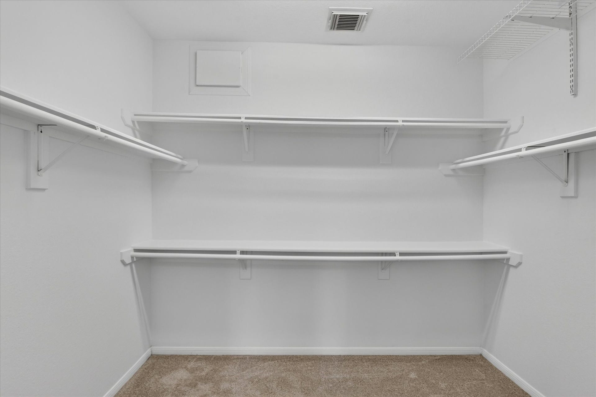 4610 Misty Morning Court, Missouri City, TX 77459 This photo shows a spacious primary bedroom walk-in closet with multiple white shelves and hanging rods, providing ample storage. The carpeted floor and white walls create a clean, open feel.