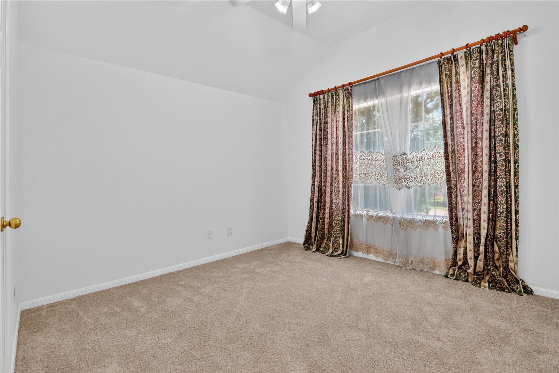 4610 Misty Morning Court, Missouri City, TX 77459 This bedroom features neutral carpeting, white walls, and a window with decorative curtains, offering a cozy and bright atmosphere.
