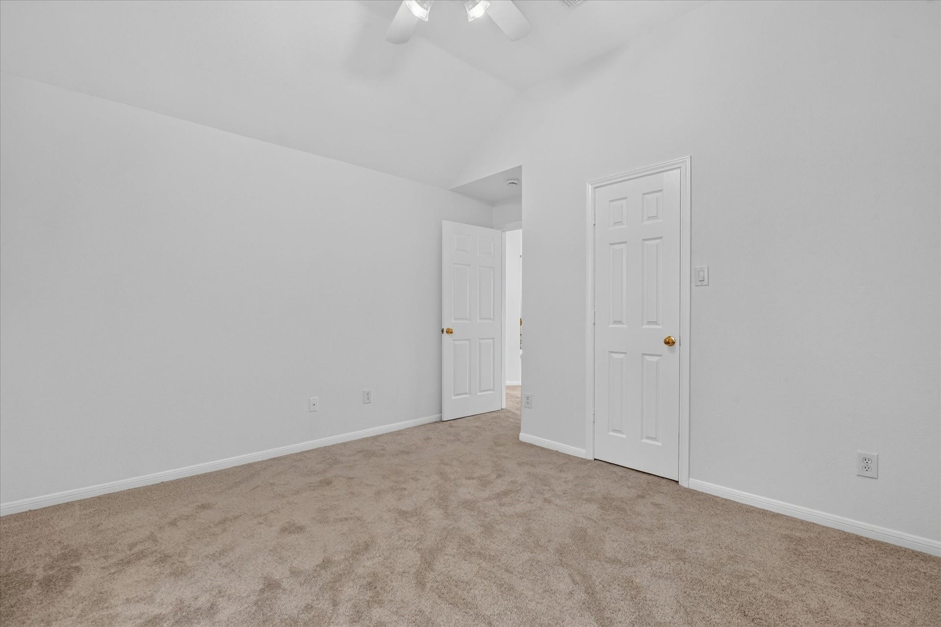 4610 Misty Morning Court, Missouri City, TX 77459 This bedroom features soft carpet flooring, white walls, and a ceiling fan. It includes two doors and ample natural light, providing a bright and inviting space.