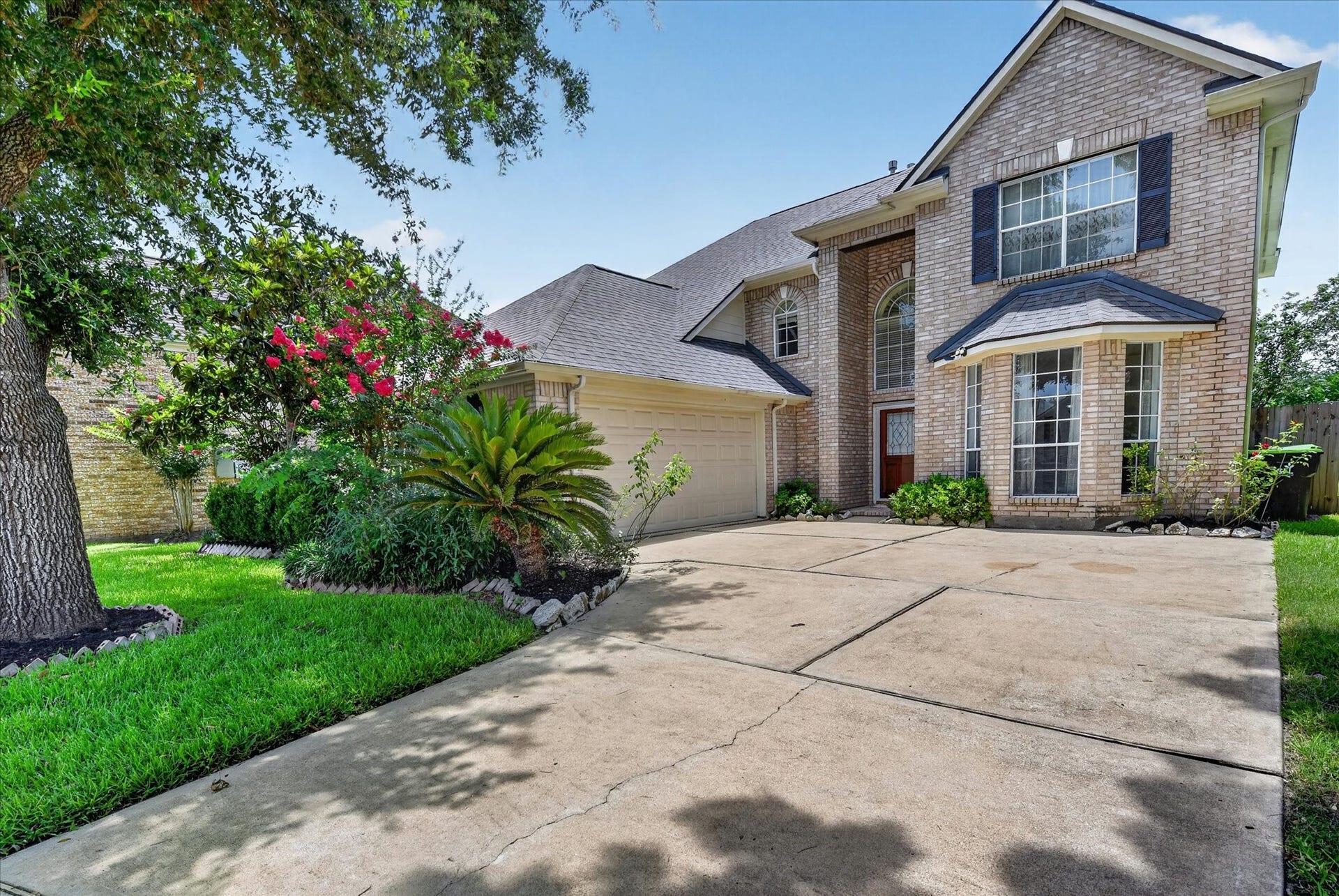 4610 Misty Morning Court, Missouri City, TX 77459 This inviting two-story brick home features a spacious driveway, charming front garden with lush greenery, and a welcoming entrance. Ideal for comfortable family living.