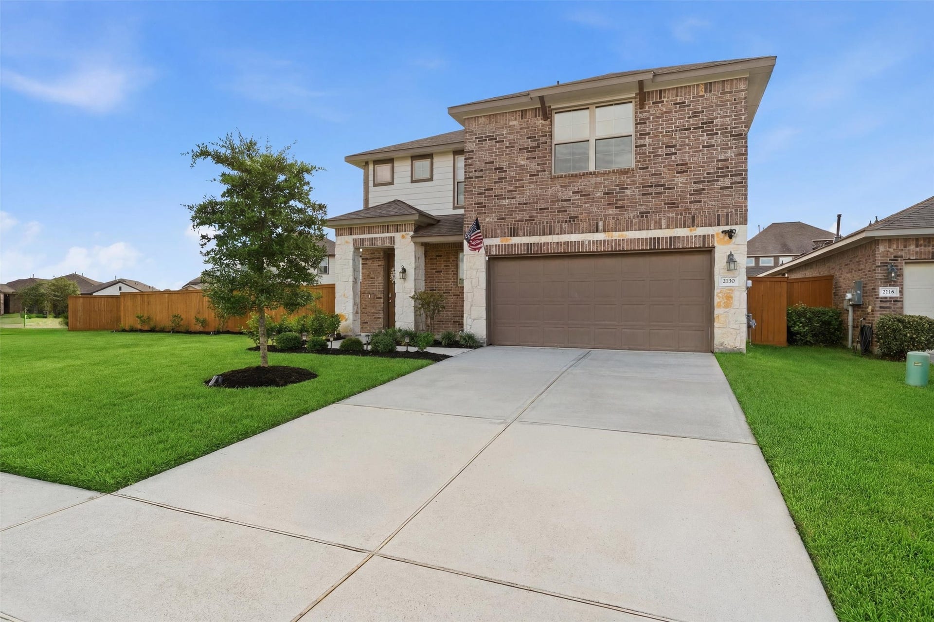 2130 Shellbark Way, La Marque, TX 77568 The property features a welcoming front yard with neat landscaping and a driveway, set against a backdrop of a serene evening sky.