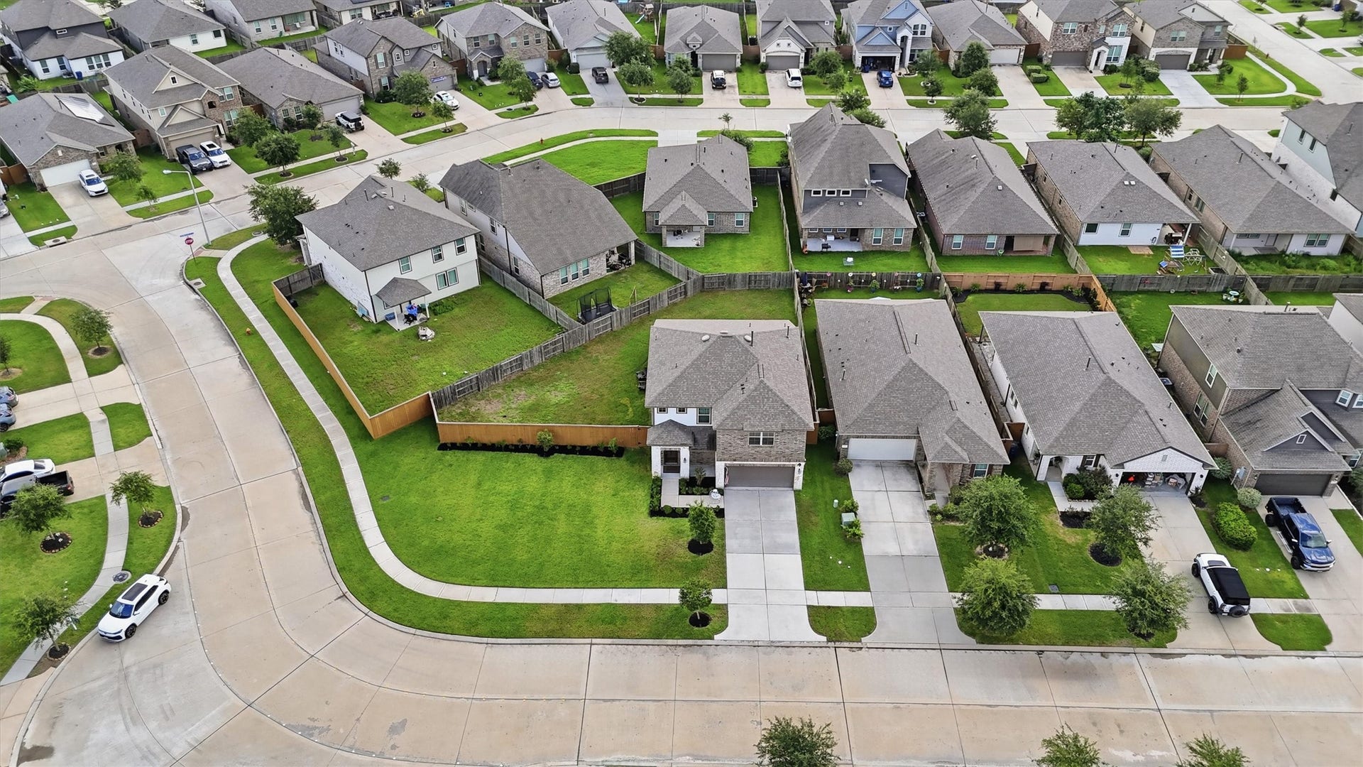 2130 Shellbark Way, La Marque, TX 77568 Aerial photo showcases a suburban neighborhood with well-maintained homes. The area has neatly landscaped lawns and is situated on a winding street, offering a peaceful and organized residential setting.