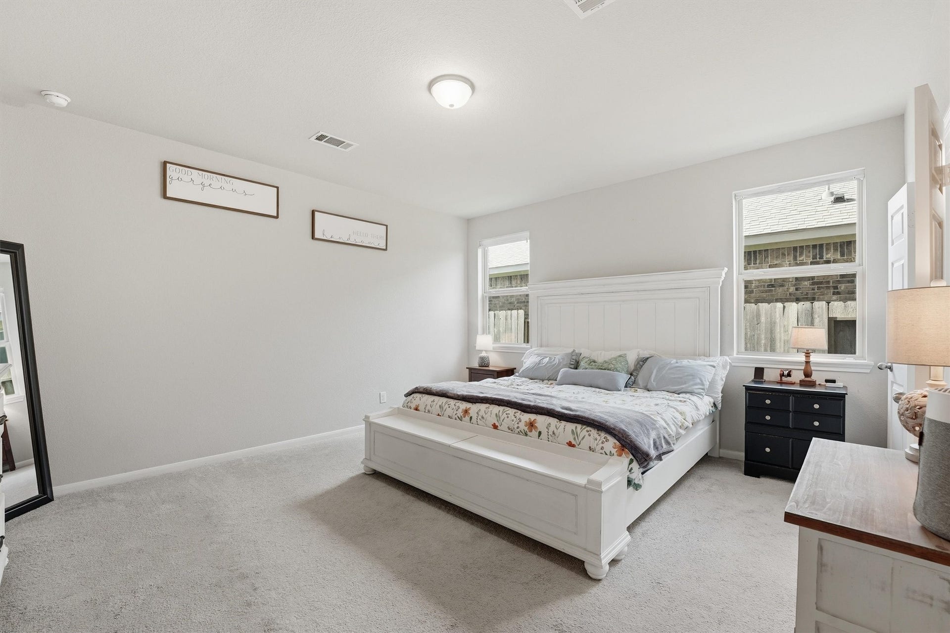2130 Shellbark Way, La Marque, TX 77568 Spacious primary bedroom with neutral tones, ample natural light from two windows, and a cozy carpet.