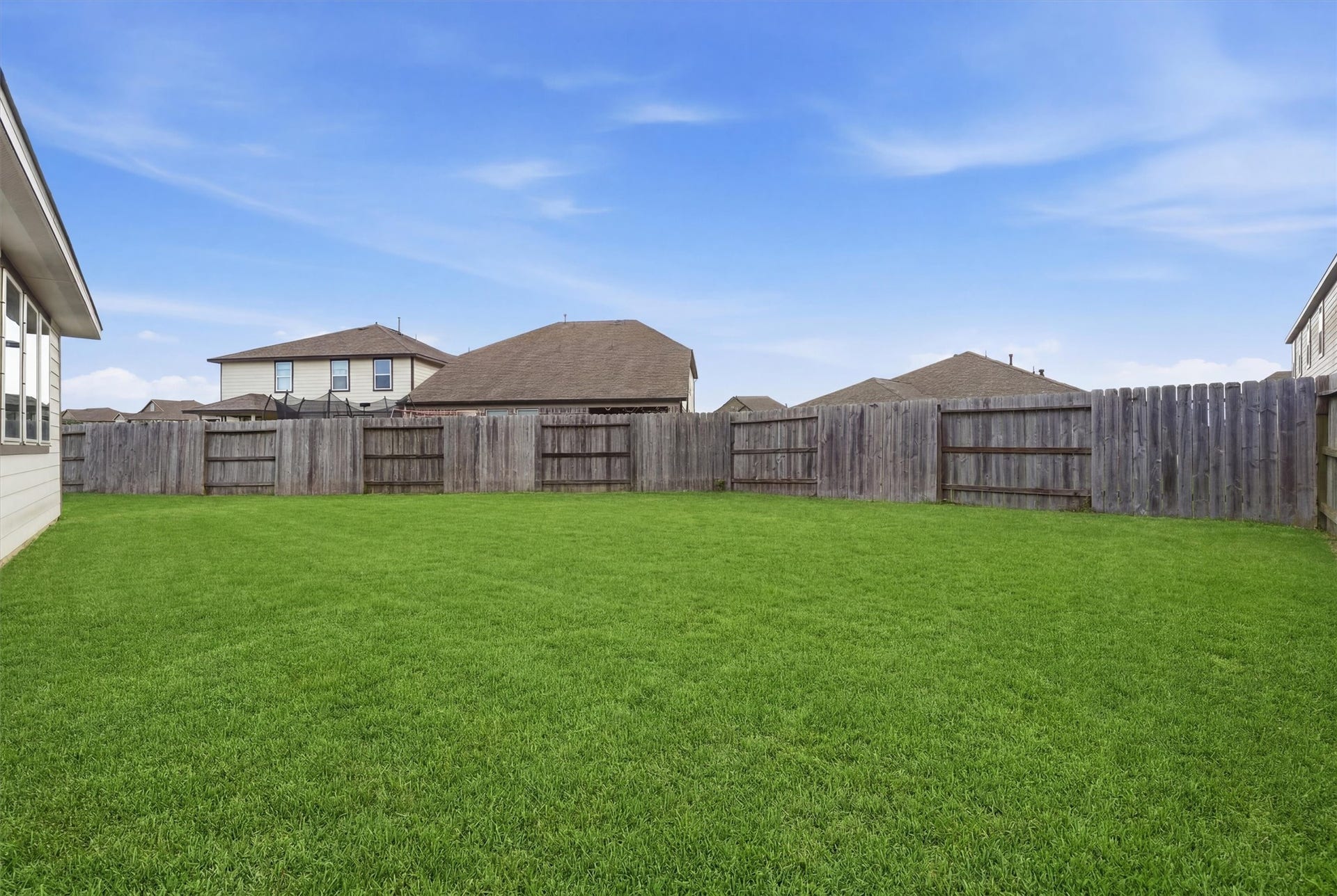 2130 Shellbark Way, La Marque, TX 77568 Pool sized backyard with a well-maintained lawn, enclosed by a wooden privacy fence, ideal for outdoor activities and gardening.