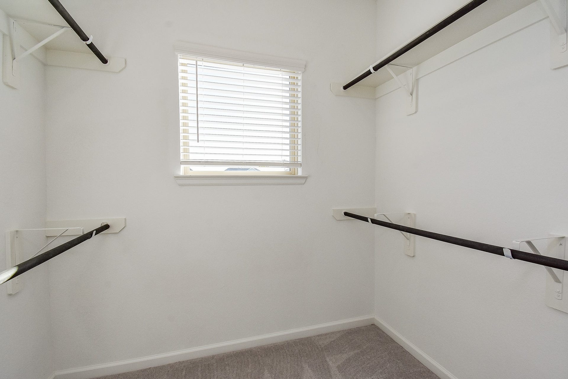 Primary bedroom closet with a small window for natural light.