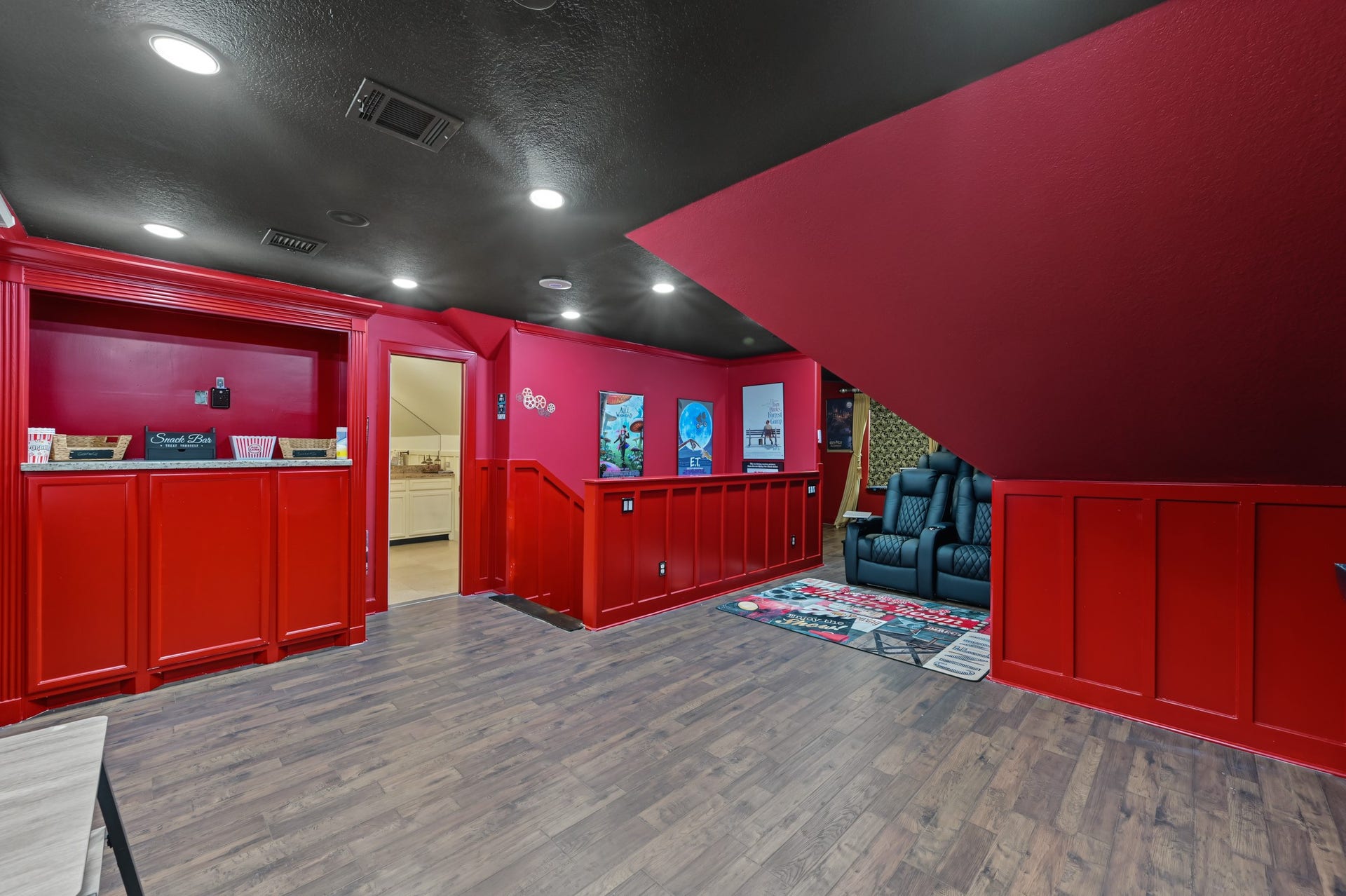 Experience cinematic luxury in this vibrant home theater, featuring plush reclining seats, classic movie posters, and a cozy ambiance perfect for entertainment. Complete with a projection system, surround sound speakers, and mini fridge, snack bar, soda stream, and popcorn machine ready for all your entertainment needs!
