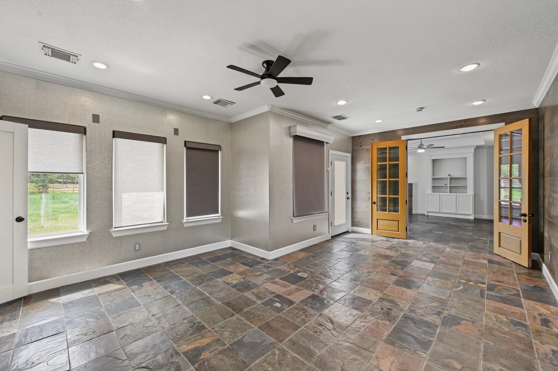 Another view of this beautiful room with large windows and french doors leading to primary suite.