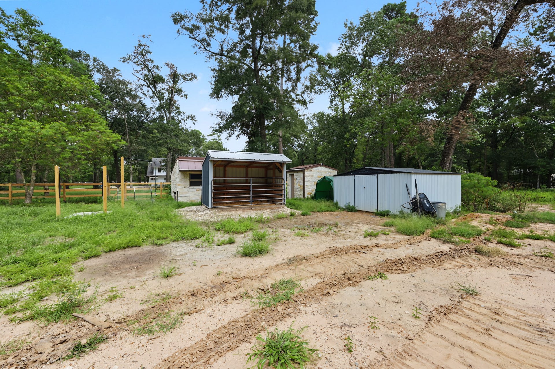 Expansive backyard features a horse stall and horse washing station.
