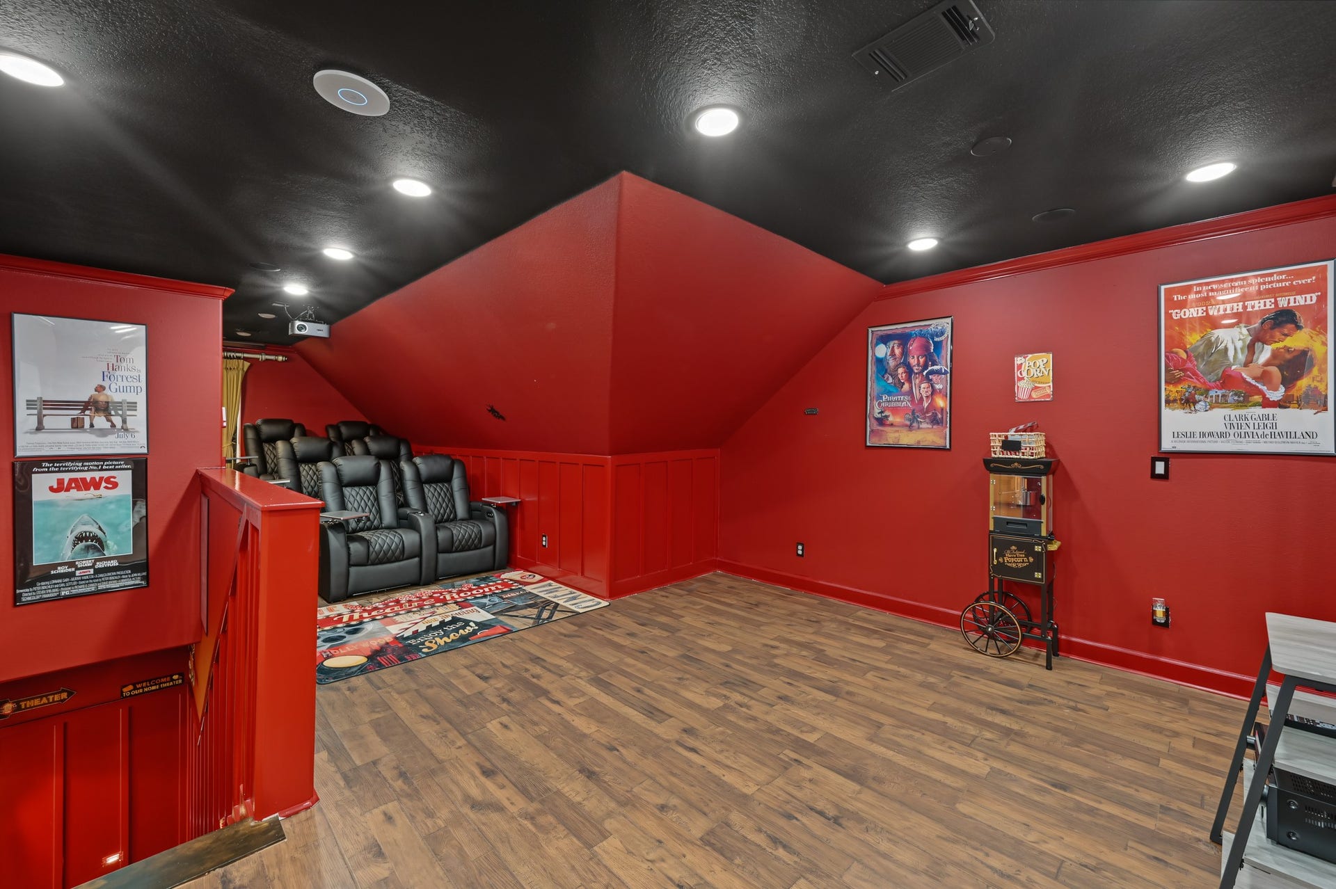 Experience cinematic luxury in this vibrant home theater, featuring plush reclining seats, classic movie posters, and a cozy ambiance perfect for entertainment.