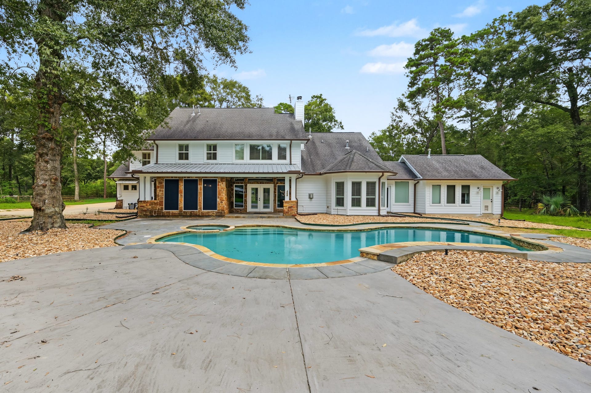 Experience luxury with this stunning backyard oasis featuring an inviting pool surrounded by lush greenery and elegant stonework, perfect for relaxation and entertaining.