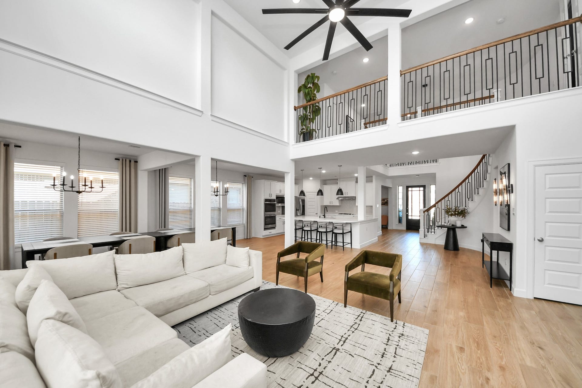 5542 Fairfield Lane, Pasadena, TX 77505 Spacious open-concept living area with high ceilings, modern finishes, and ample natural light, featuring a stylish kitchen, elegant staircase, and cozy seating perfect for entertaining.