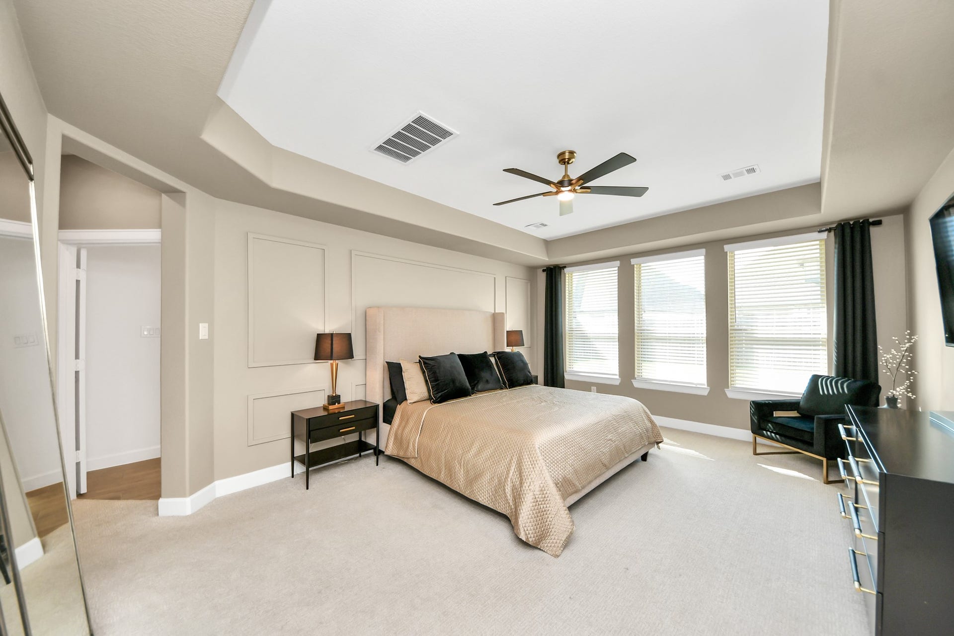 5542 Fairfield Lane, Pasadena, TX 77505 Spacious bedroom with a tray ceiling, ample natural light from multiple windows, and elegant neutral decor.