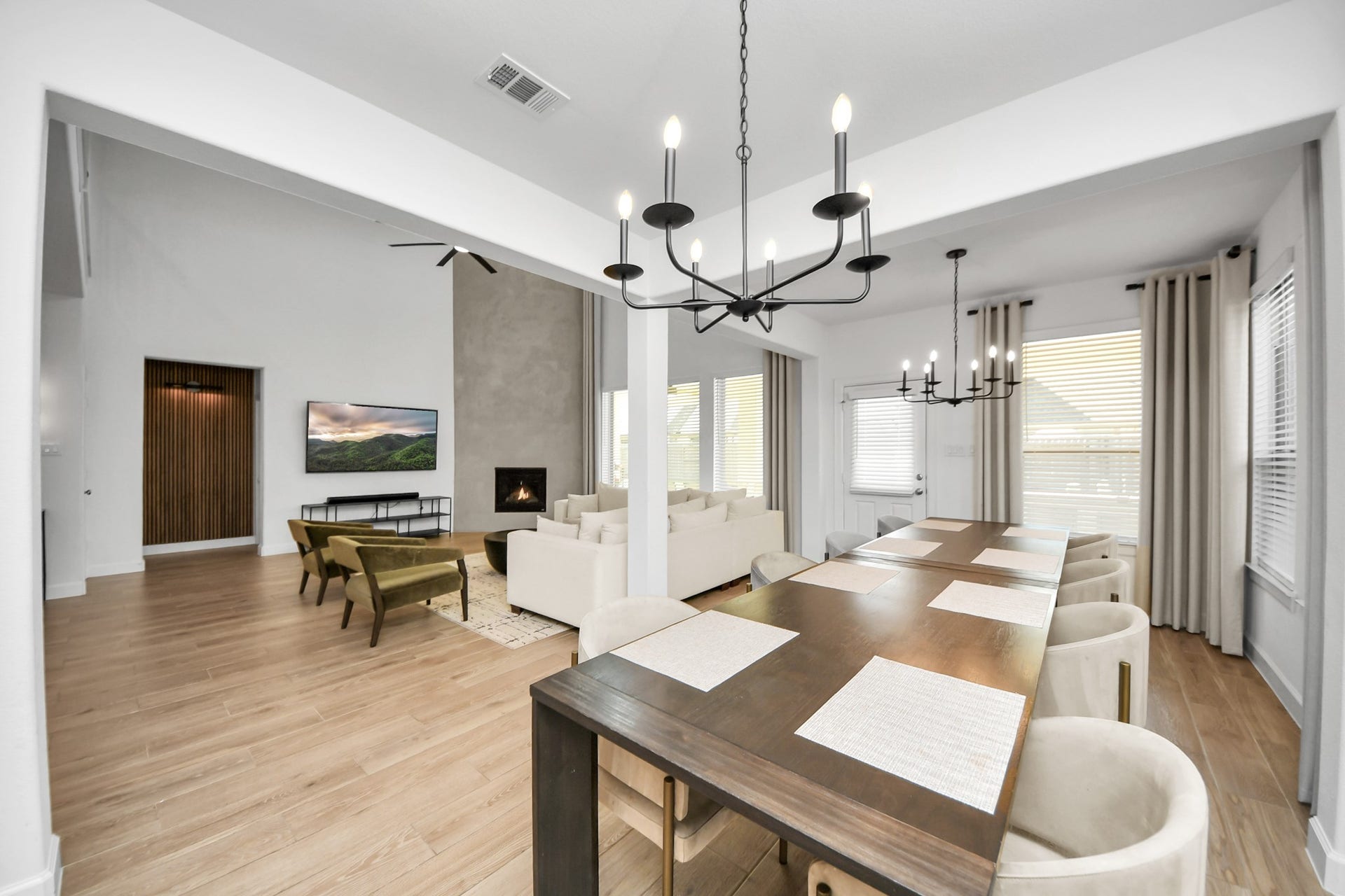 5542 Fairfield Lane, Pasadena, TX 77505 Spacious open-concept living and dining area with elegant chandeliers, a cozy fireplace, and natural light streaming through large windows.