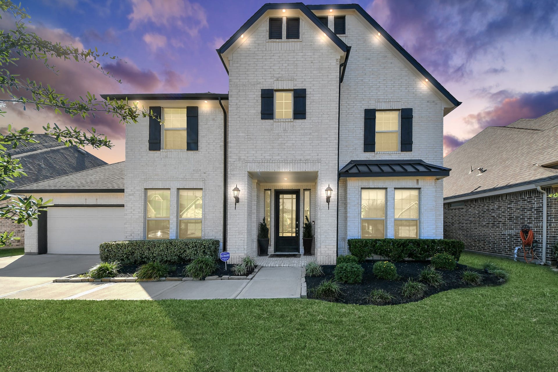 5542 Fairfield Lane, Pasadena, TX 77505 Charming two-story brick home with elegant shutters, a welcoming front porch, and beautifully manicured landscaping set against a stunning sunset sky.