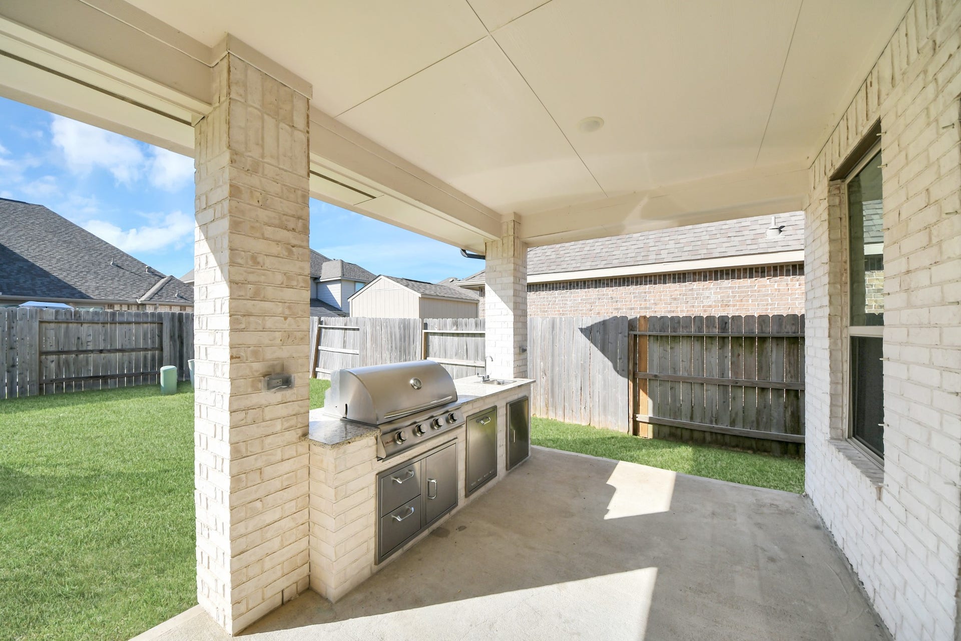 5542 Fairfield Lane, Pasadena, TX 77505 Spacious covered patio featuring a built-in outdoor grill and ample room for entertaining in a private fenced yard.
