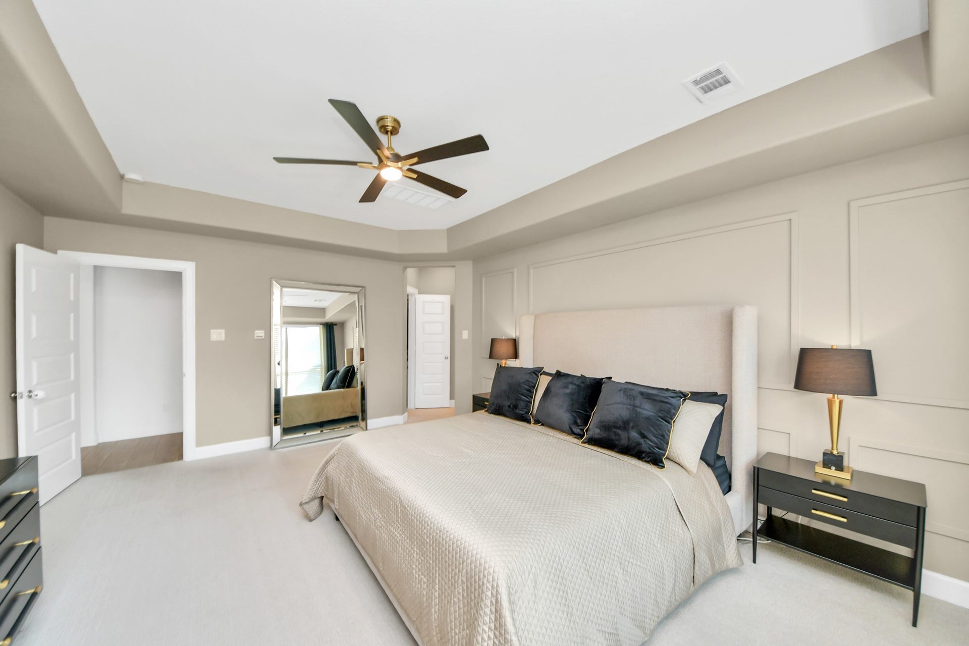 5542 Fairfield Lane, Pasadena, TX 77505 Spacious and elegant bedroom featuring a plush bed with luxurious linens, modern ceiling fan, and stylish bedside lamps, all complemented by soft neutral tones and ample natural light.