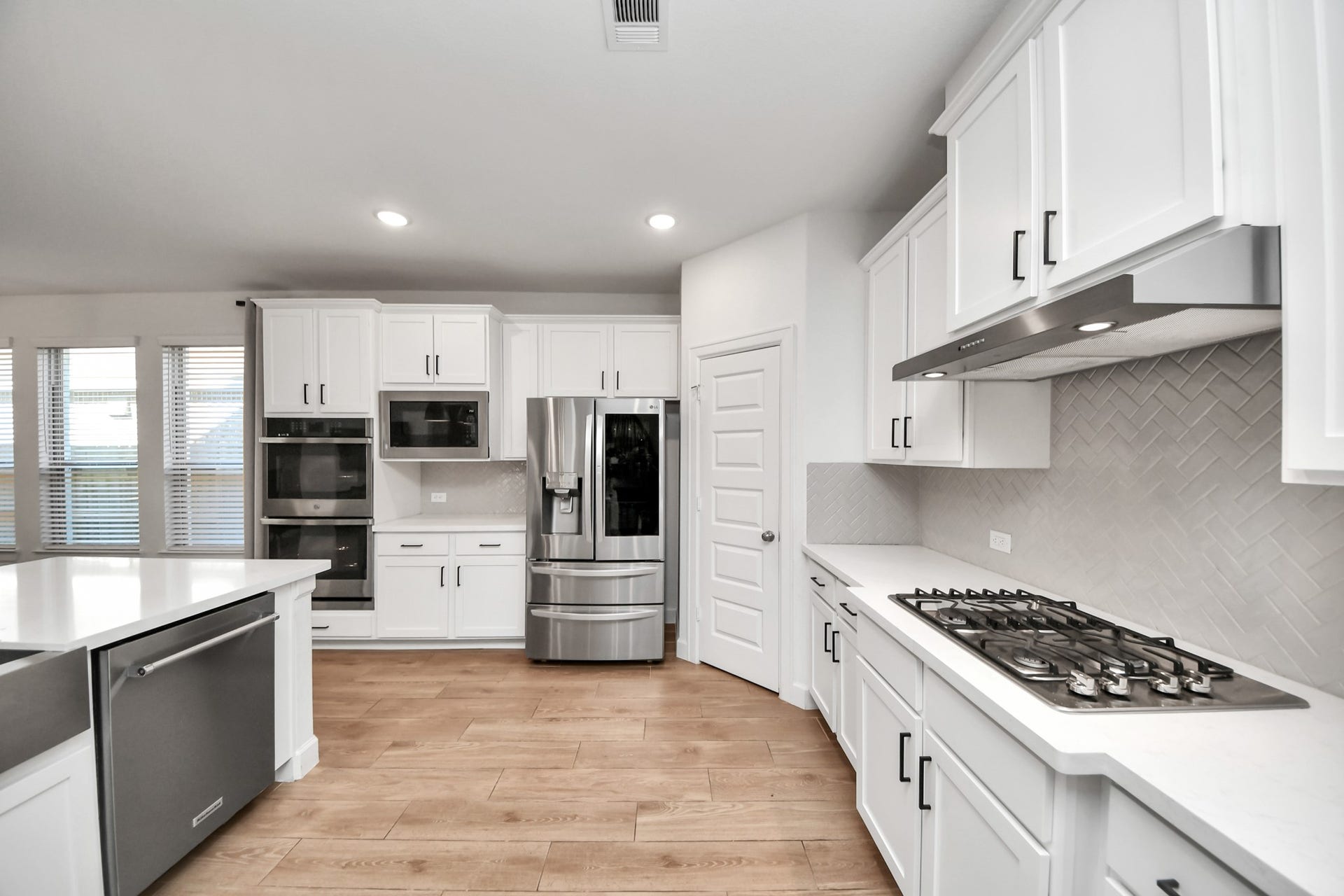 5542 Fairfield Lane, Pasadena, TX 77505 Modern kitchen with sleek stainless steel appliances, white cabinetry, and a spacious island, perfect for culinary enthusiasts.