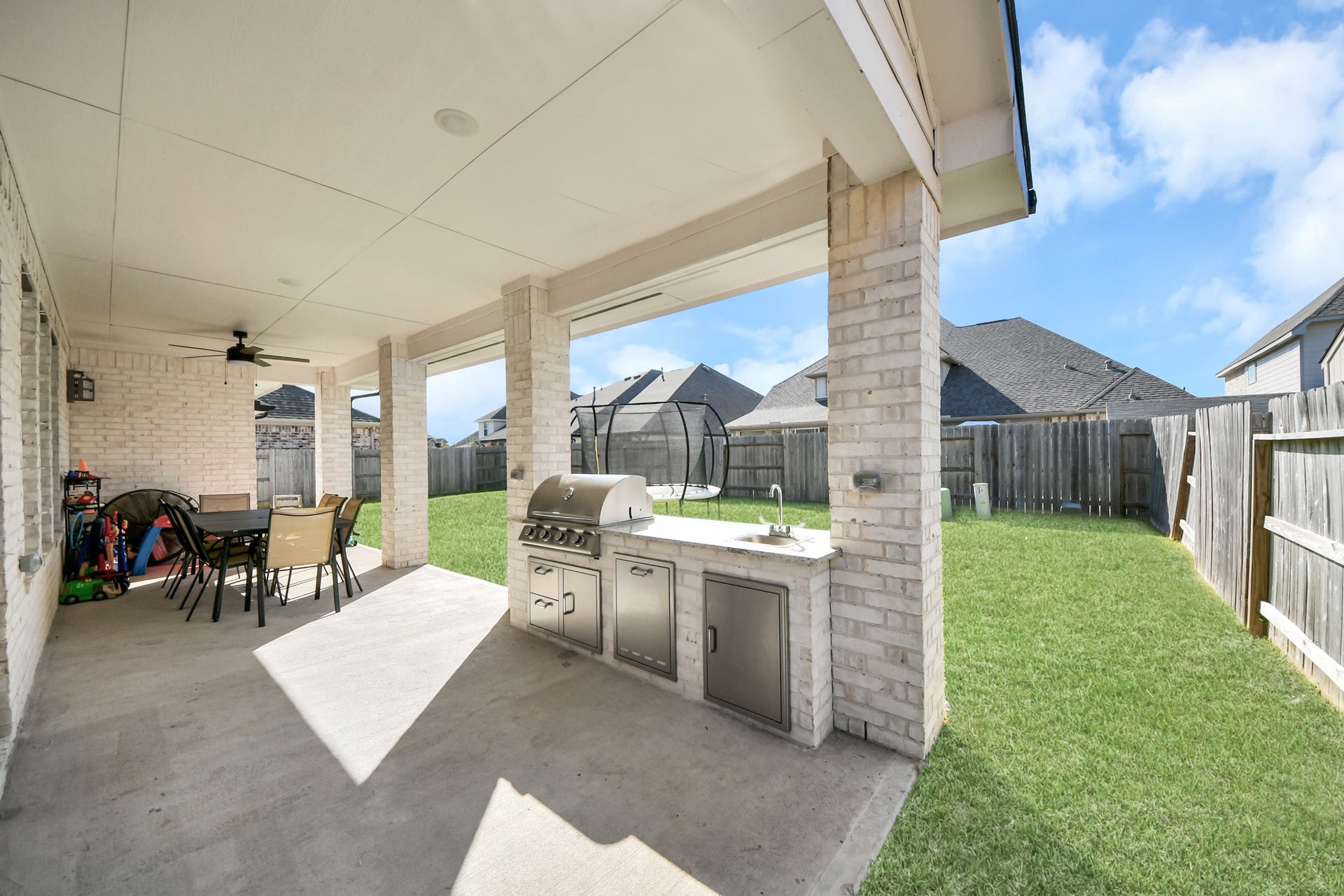 5542 Fairfield Lane, Pasadena, TX 77505 Spacious covered patio with an outdoor kitchen and dining area, perfect for entertaining and enjoying the fenced backyard.