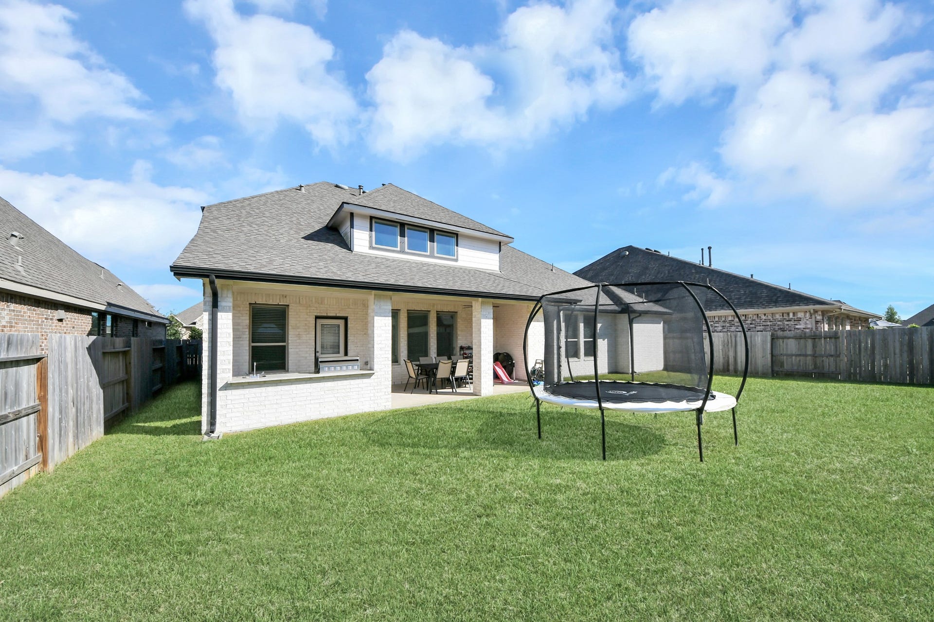 5542 Fairfield Lane, Pasadena, TX 77505 Spacious backyard with a covered patio and ample lawn space, perfect for outdoor activities and relaxation.