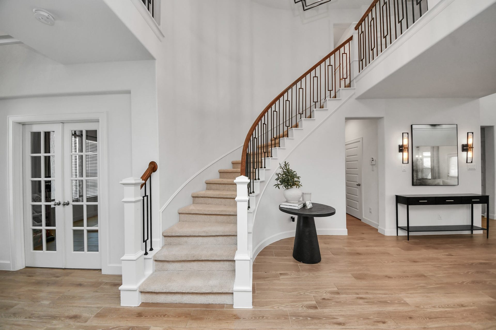 5542 Fairfield Lane, Pasadena, TX 77505 Elegant foyer with a sweeping staircase and hardwood floors, complemented by a stylish console and modern lighting.