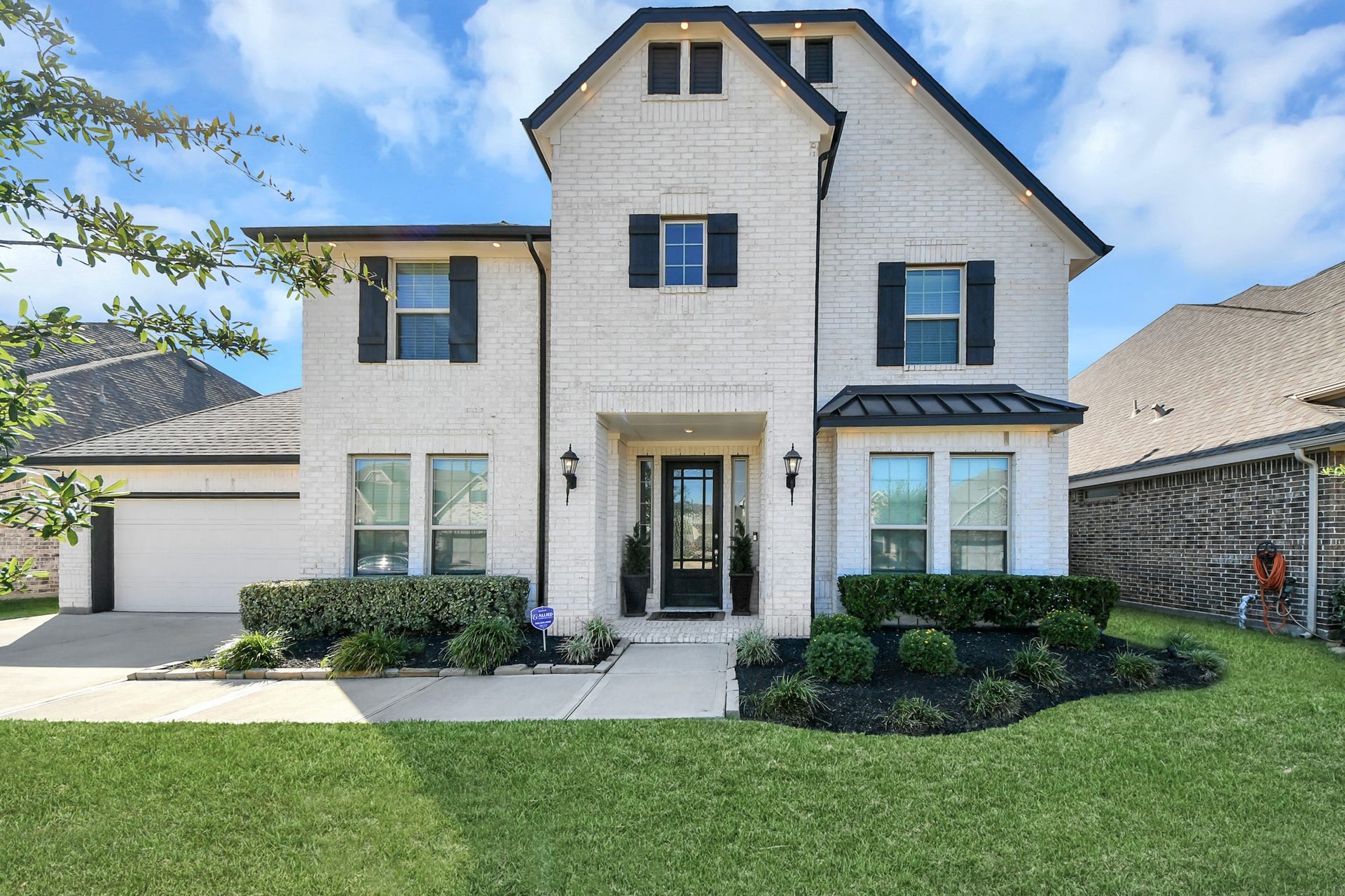 5542 Fairfield Lane, Pasadena, TX 77505 Stunning two-story home with elegant white brick faade, charming black shutters, and a beautifully landscaped front yard.