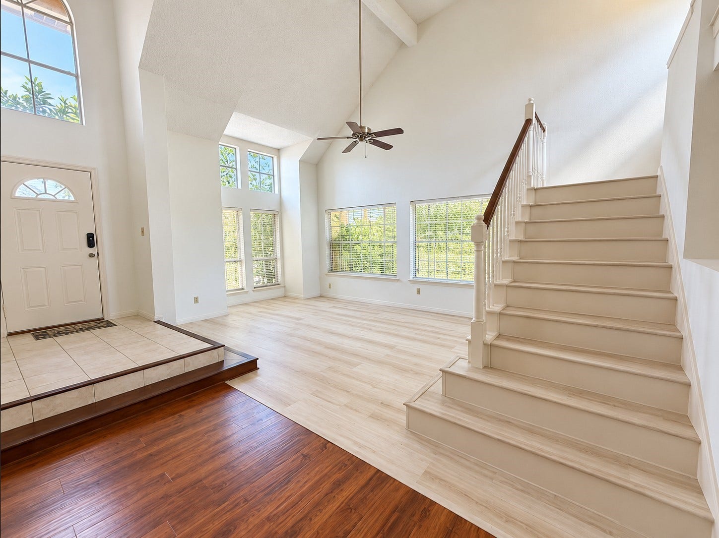 Welcoming foyer with high ceilings and staircase leading to the second floor.