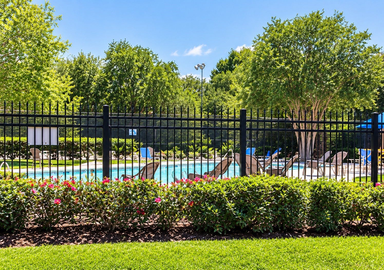 Community swimming pool surrounded by greenery and outdoor seating areas.