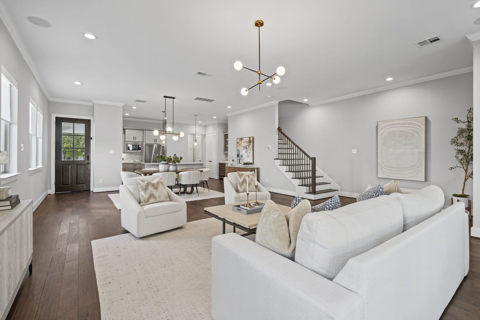 1538 Vermont Street, #A, Houston, TX 77006 Generously scaled and beautifully light-filled, the living room features warm wood floors, neutral furnishings, and a striking staircase that adds architectural interest.