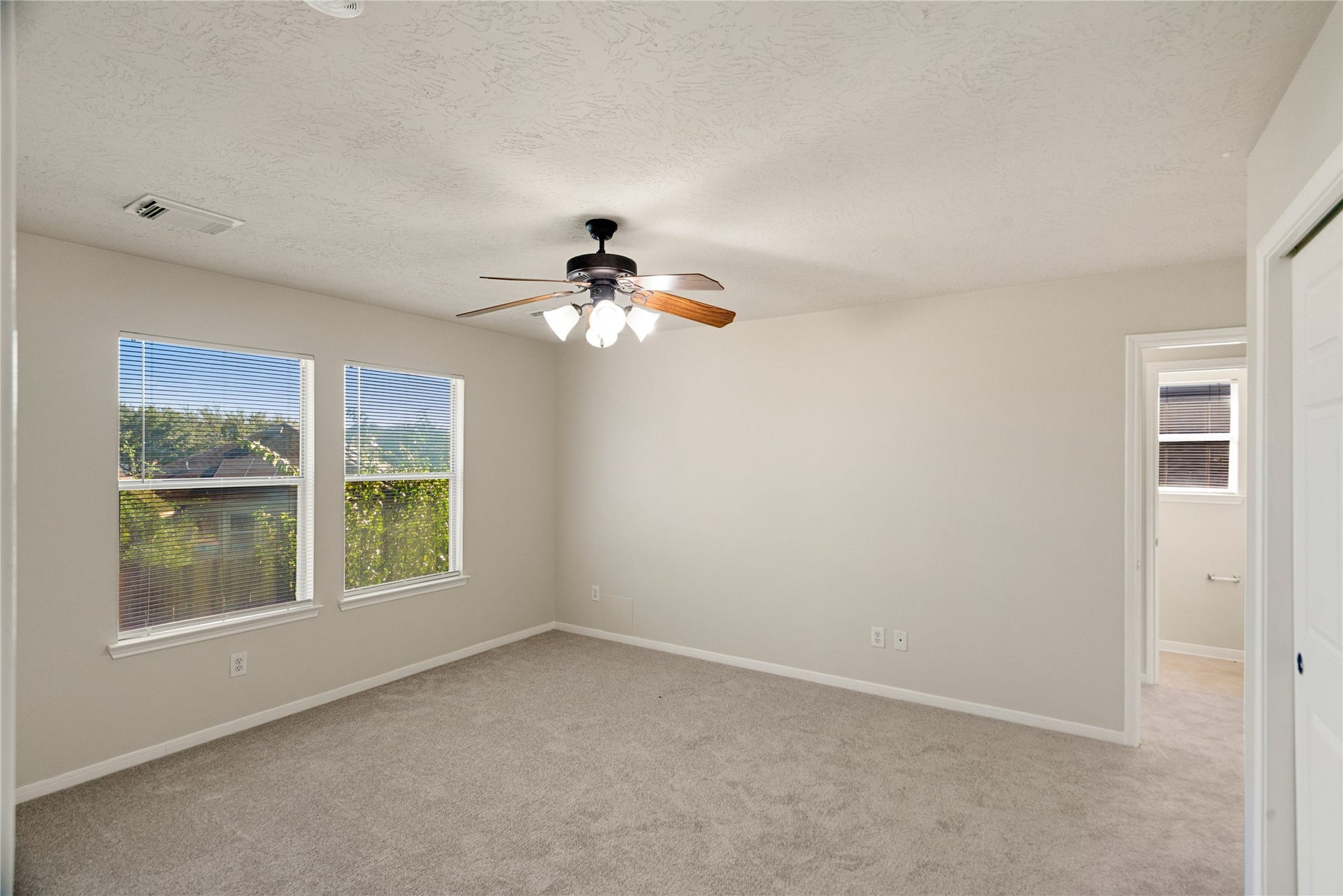 Primary bedroom featuring abundant natural light and carpet floors.