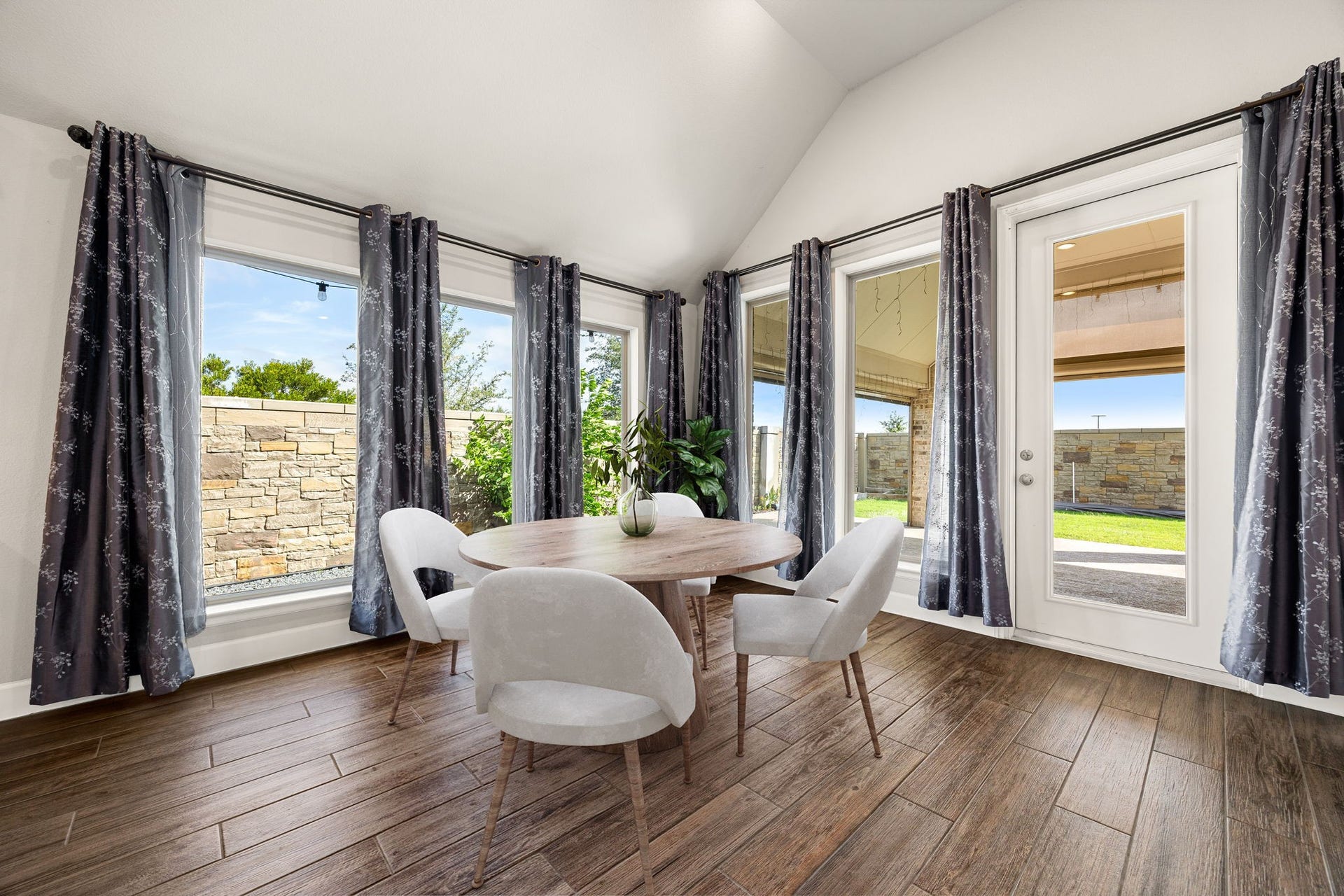 Dining feels like an upscale, indoor-outdoor experience in this magnificent alcove. Encased by massive windows that frame peaceful views of the property's stone accents and backyard greenery, this light-filled room effortlessly bridges the gap between the gourmet kitchen and your private outdoor oasis. *Virtually Staged