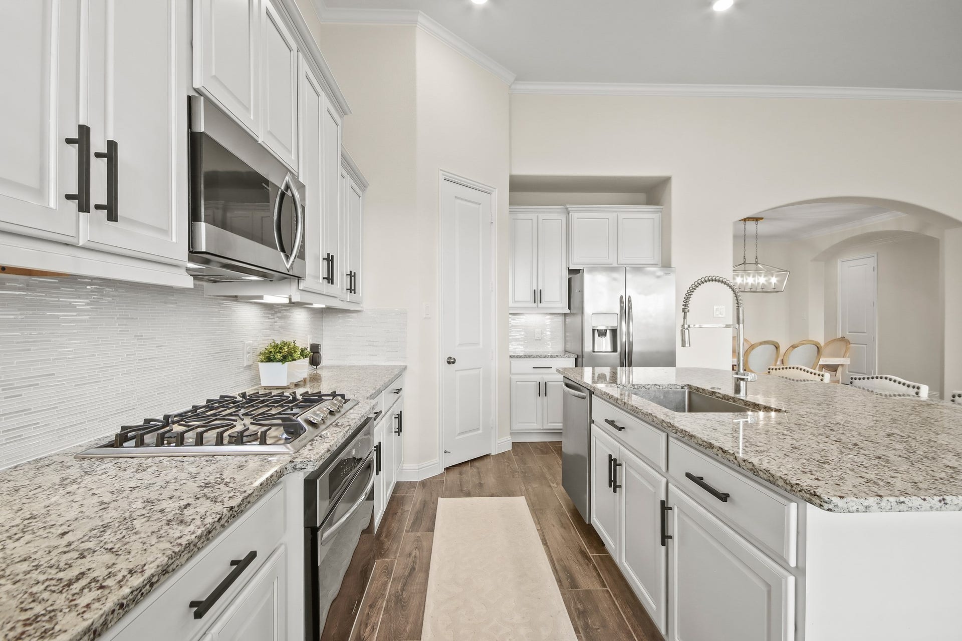 Large gas cooktop and oven, stainless steel undermount sink, microwave and upgraded kitchen faucet add to the appeal of open kitchen.