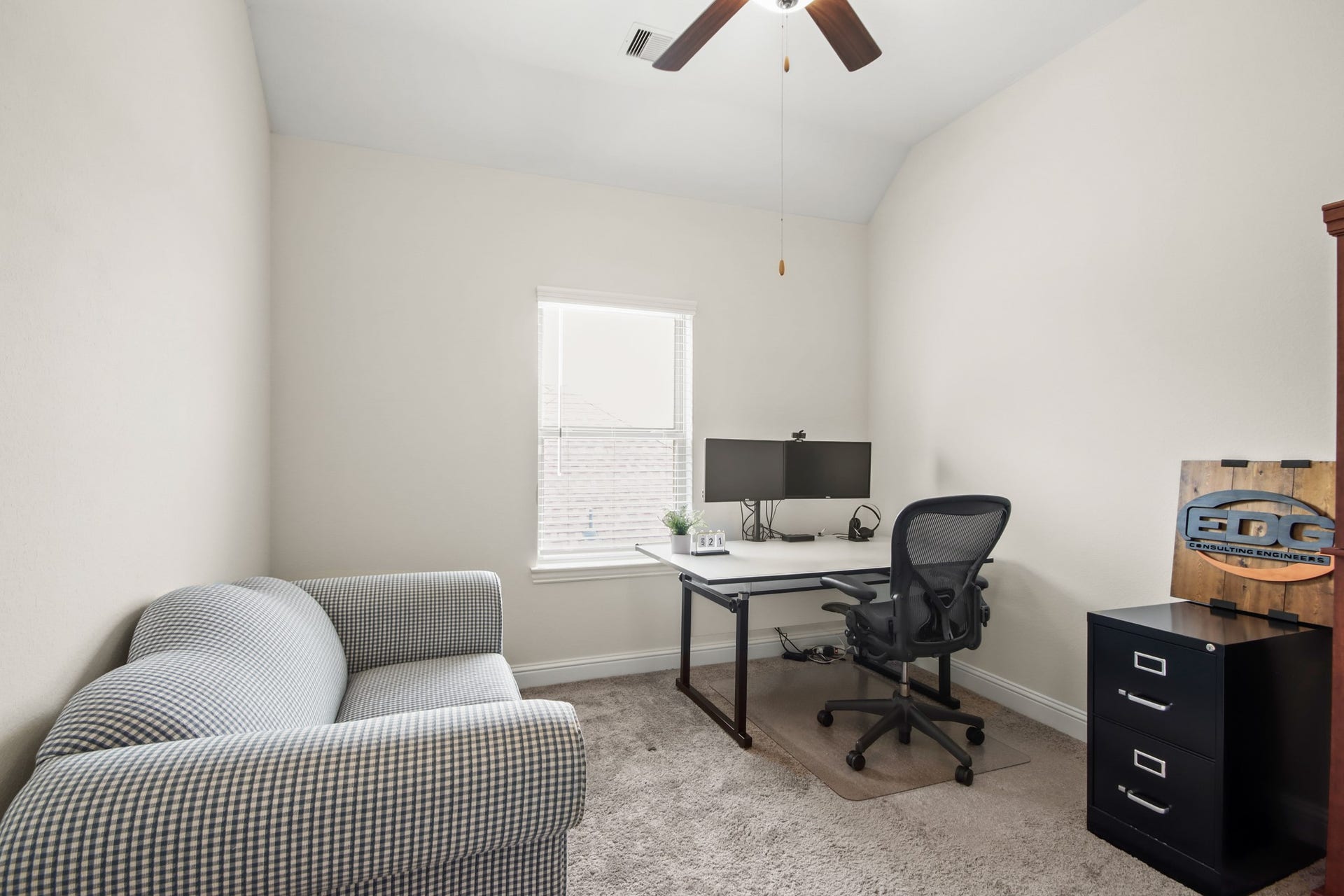 Secondary bedroom with neutral carpet, ceiling fan and window for natural light.