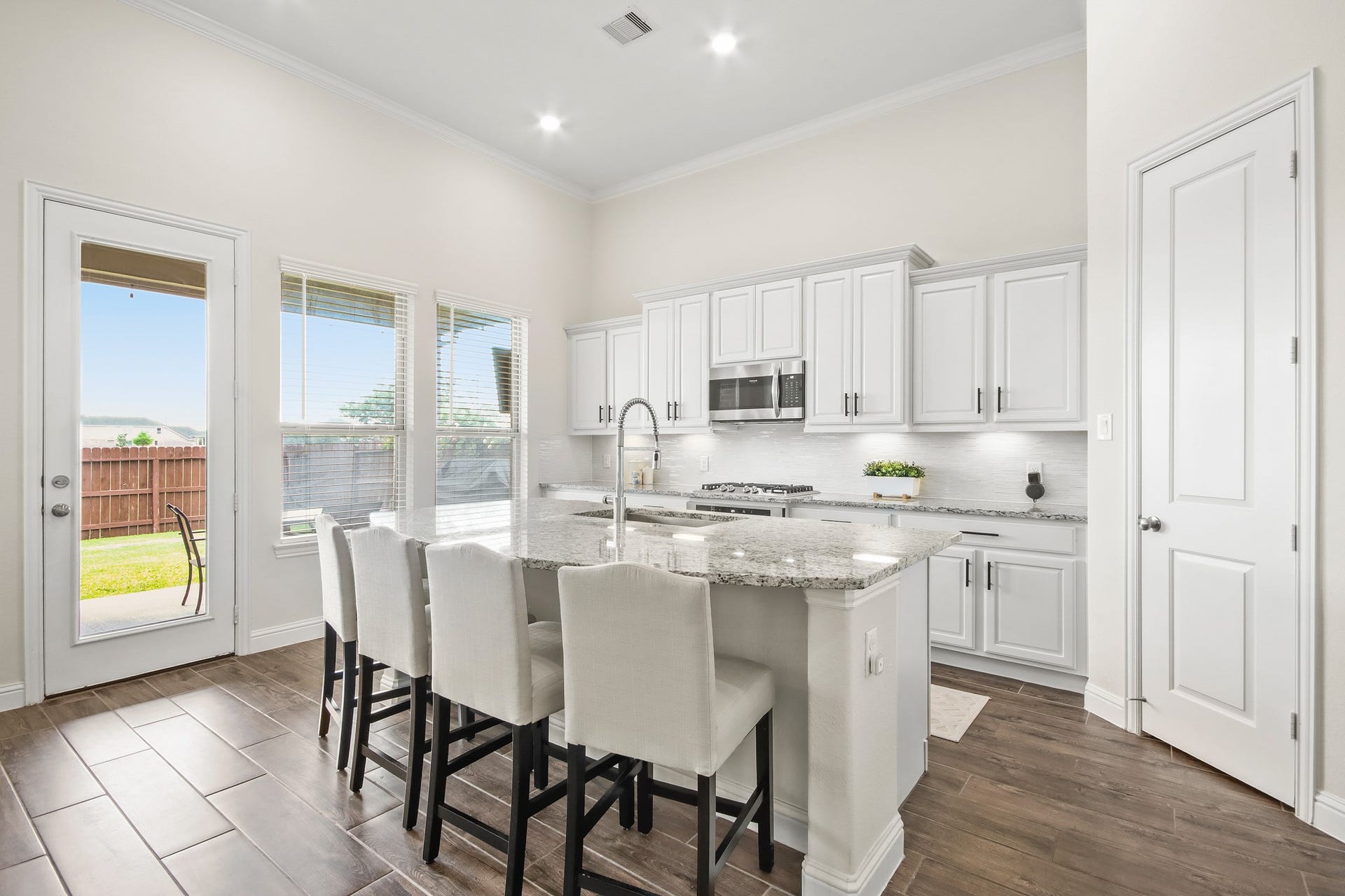 Wall of windows in kitchen and large island with seating area.