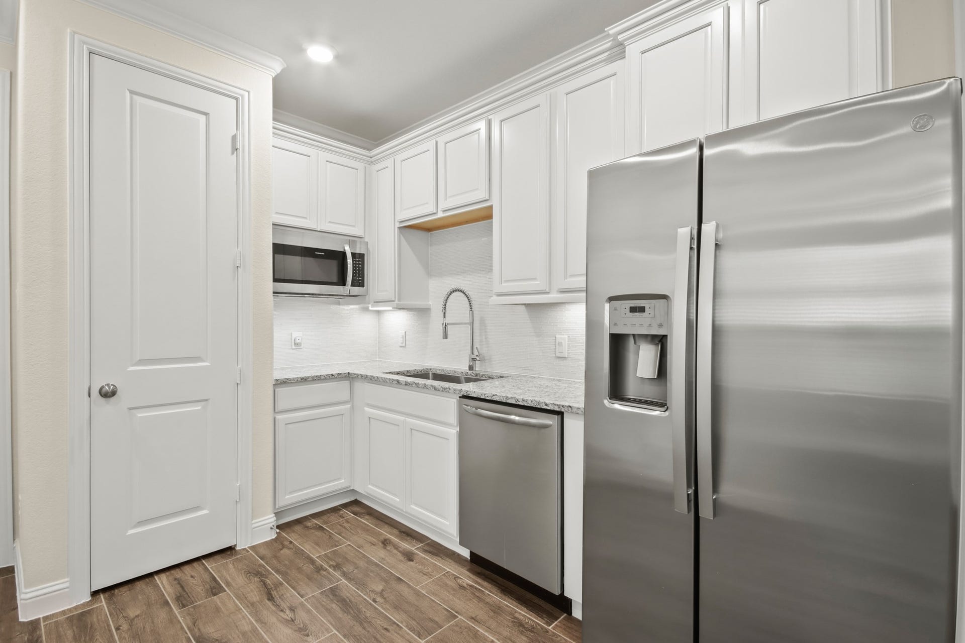 Next Gen with full kitchen, upgrade cabinets, wood tile flooring in living area.