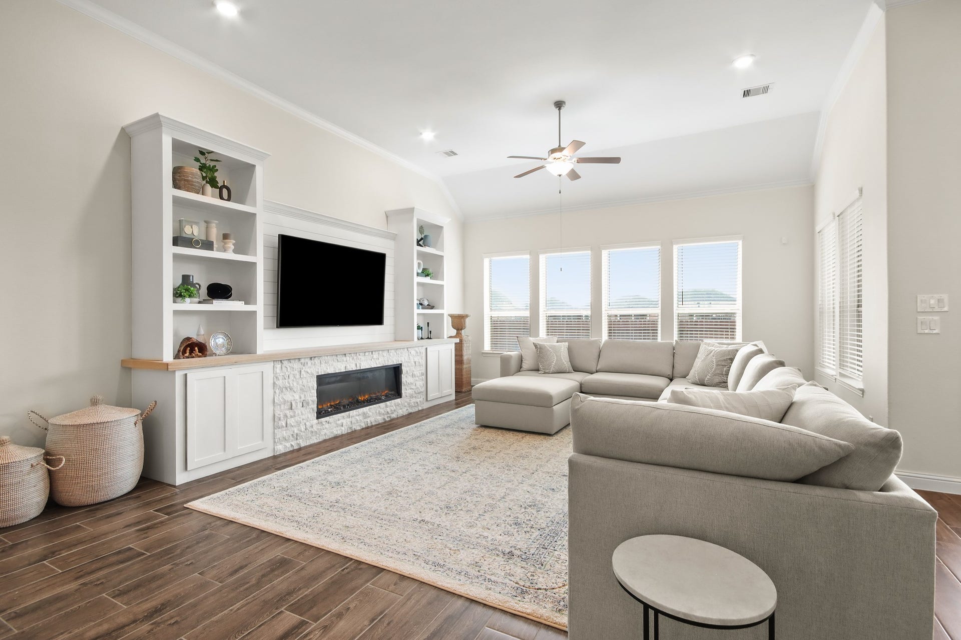 Custom built entertainment wall with cabinets, display shelving, Shiplap accent and stone gas fireplace.
