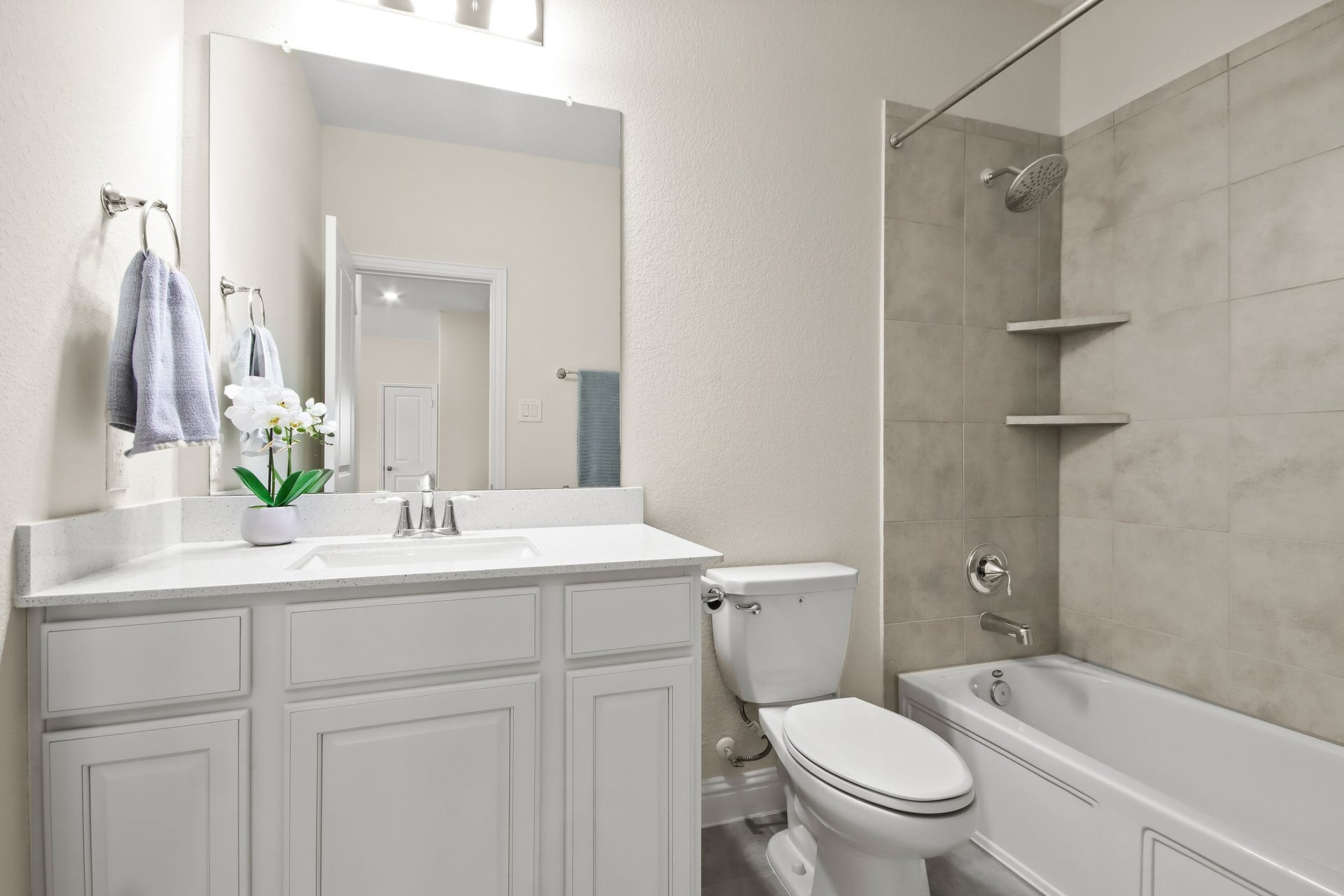 Secondary bathroom upstairs with upgraded cabinet, shower tile and floor tile.
