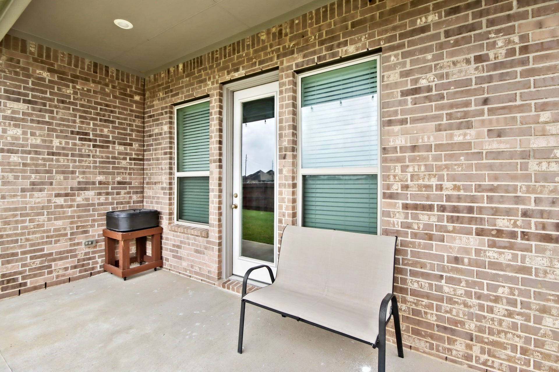 Outdoor patio off the primary bedroom with French door bookend by windows. Great space for relaxing.