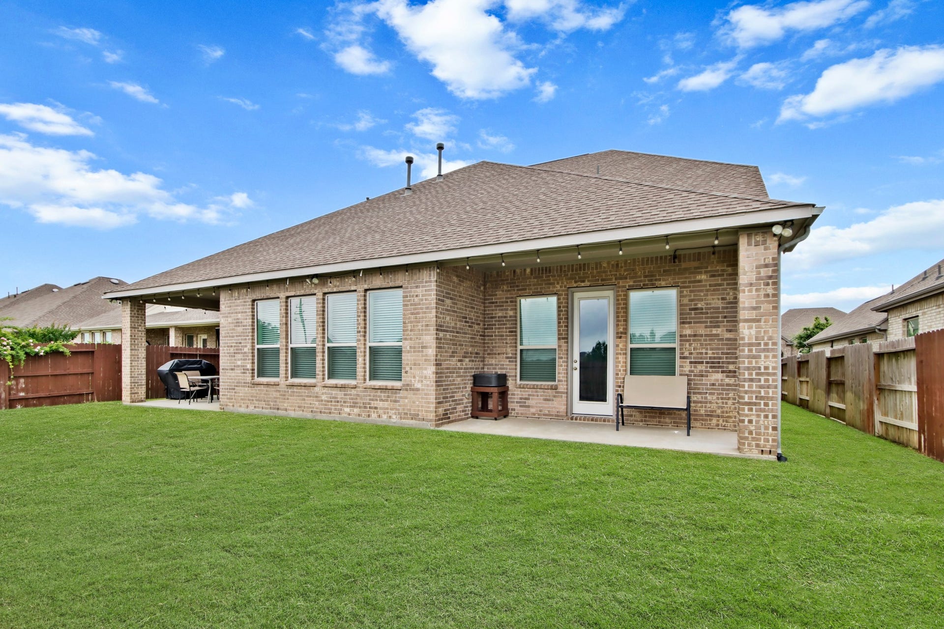 Large green space with two outdoor patios.
