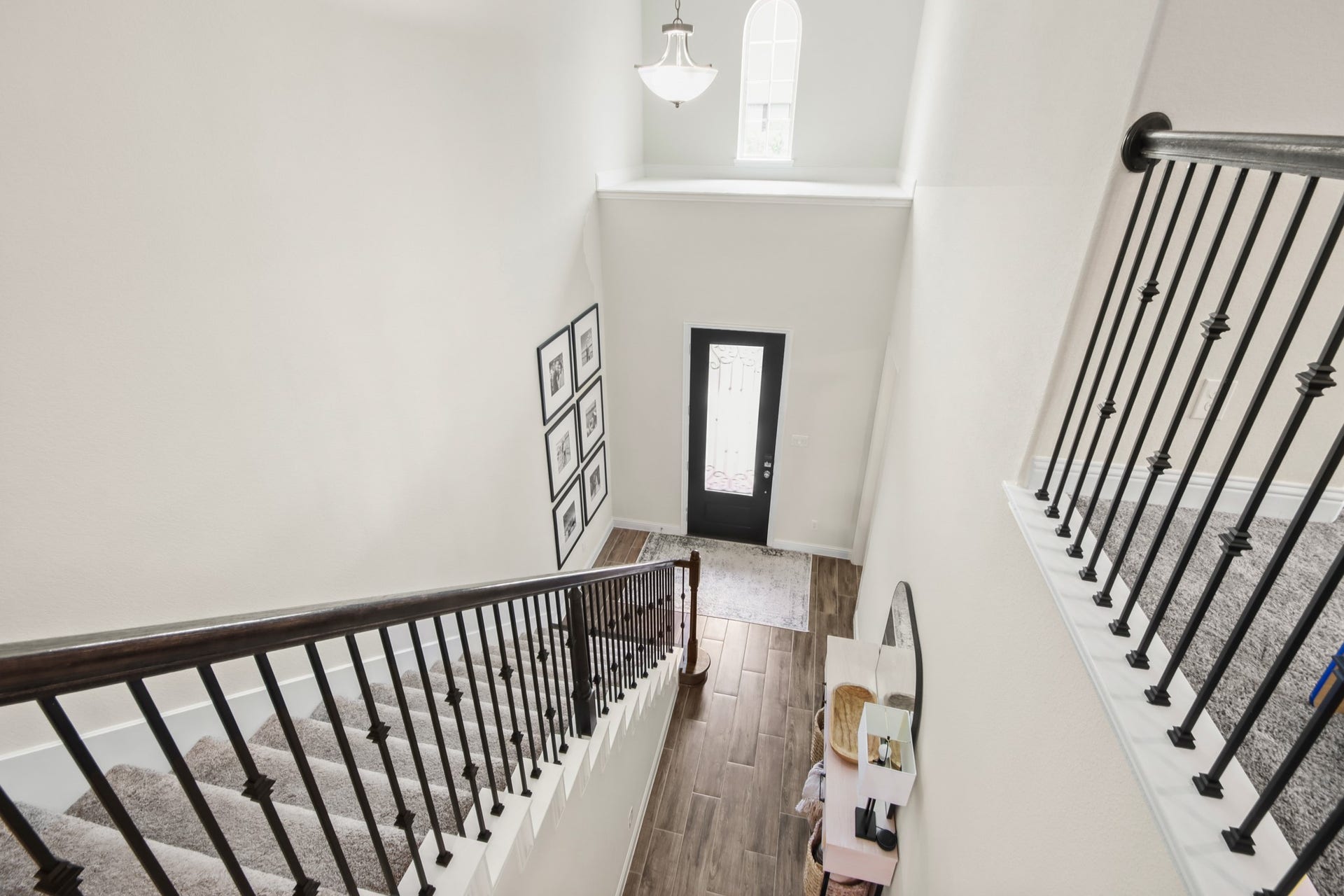 Desirable wrought iron balusters with stained wood handrail and wood stained Newel posts