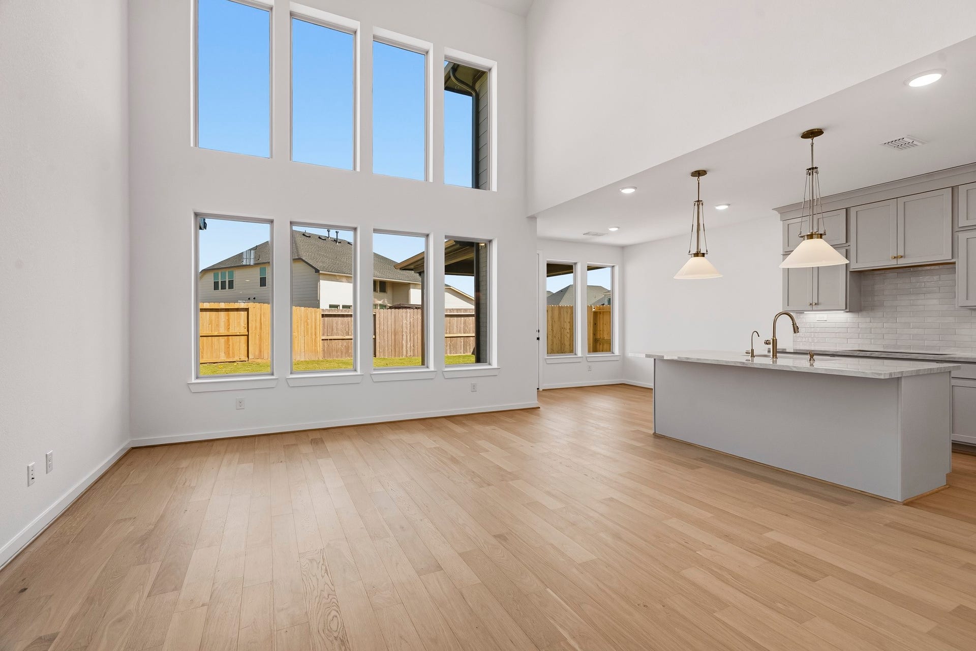4522 Sunny Hazel Lane, Fulshear, TX 77441 Dramatic two-story living space framed by walls of windows and an abundance of natural light.