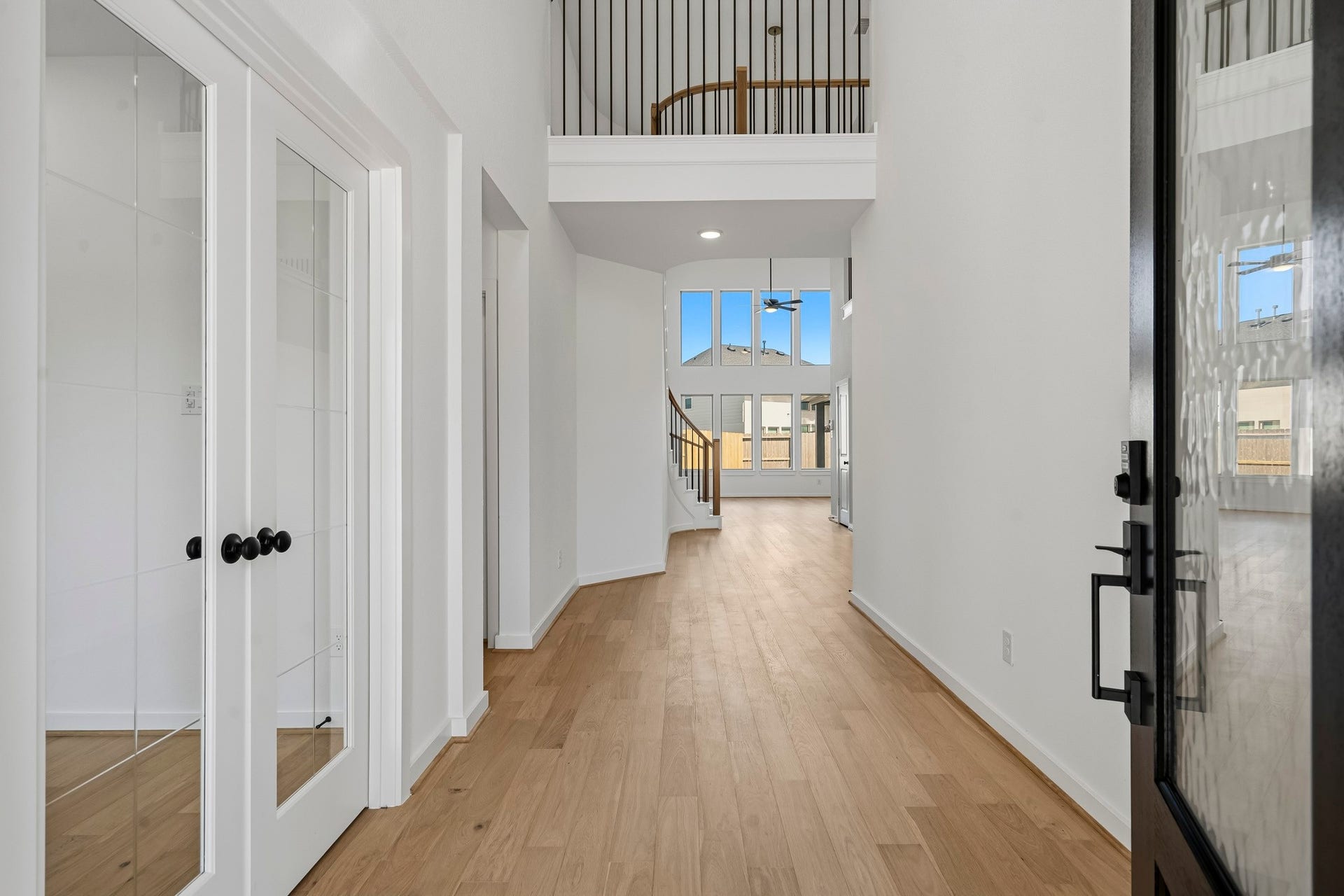 4522 Sunny Hazel Lane, Fulshear, TX 77441 Welcoming entry with wood flooring, glass French doors at the study, and soaring ceilings.