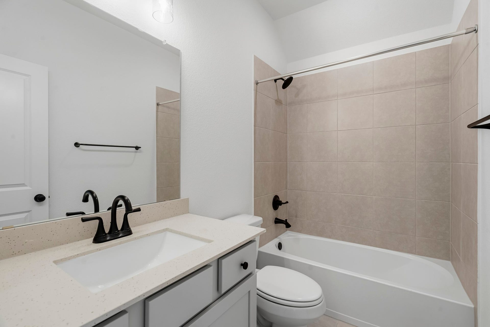 4522 Sunny Hazel Lane, Fulshear, TX 77441 Secondary bathroom with neutral tile finishes and matte black fixtures.