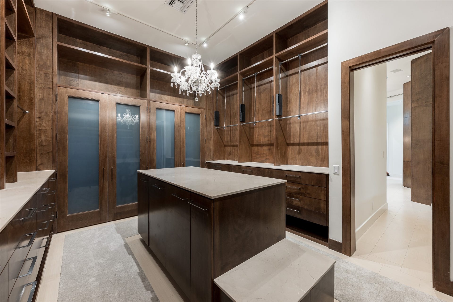 309 Glenwood Drive, Houston, TX 77007 The expansive primary closet is fully custom built with floor-to-ceiling cabinetry, integrated lighting and extensive hanging and storage space. A large center island adds additional storage and counter space, creating a highly functional dressing environment within the primary suite.
