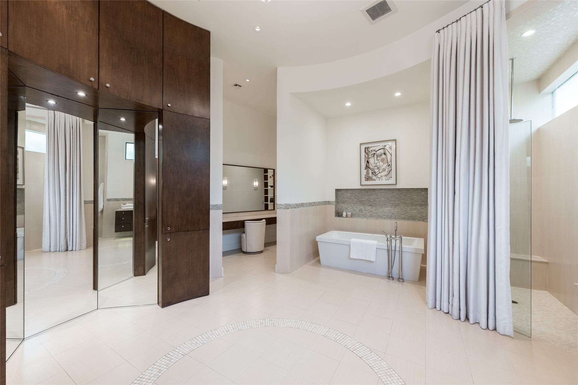 309 Glenwood Drive, Houston, TX 77007 A full mirrored dressing and vanity area to the left is complemented by additional custom cabinetry, creating a dedicated space for personal preparation.
