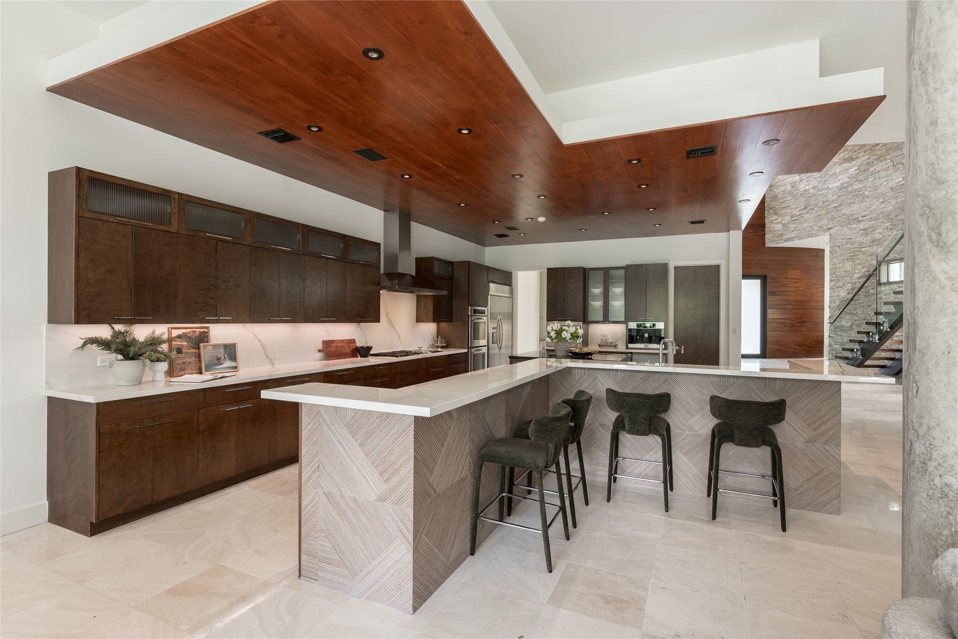 309 Glenwood Drive, Houston, TX 77007 The expansive tabletop island is finished with a distinctive patterned tile, adding another layer of custom design to the kitchen. Cabinet upper display cabinetry frames an impressive stretch of back counterspace, while this angle begins to reveal the suite of high end appliances integrated throughout the kitchen.