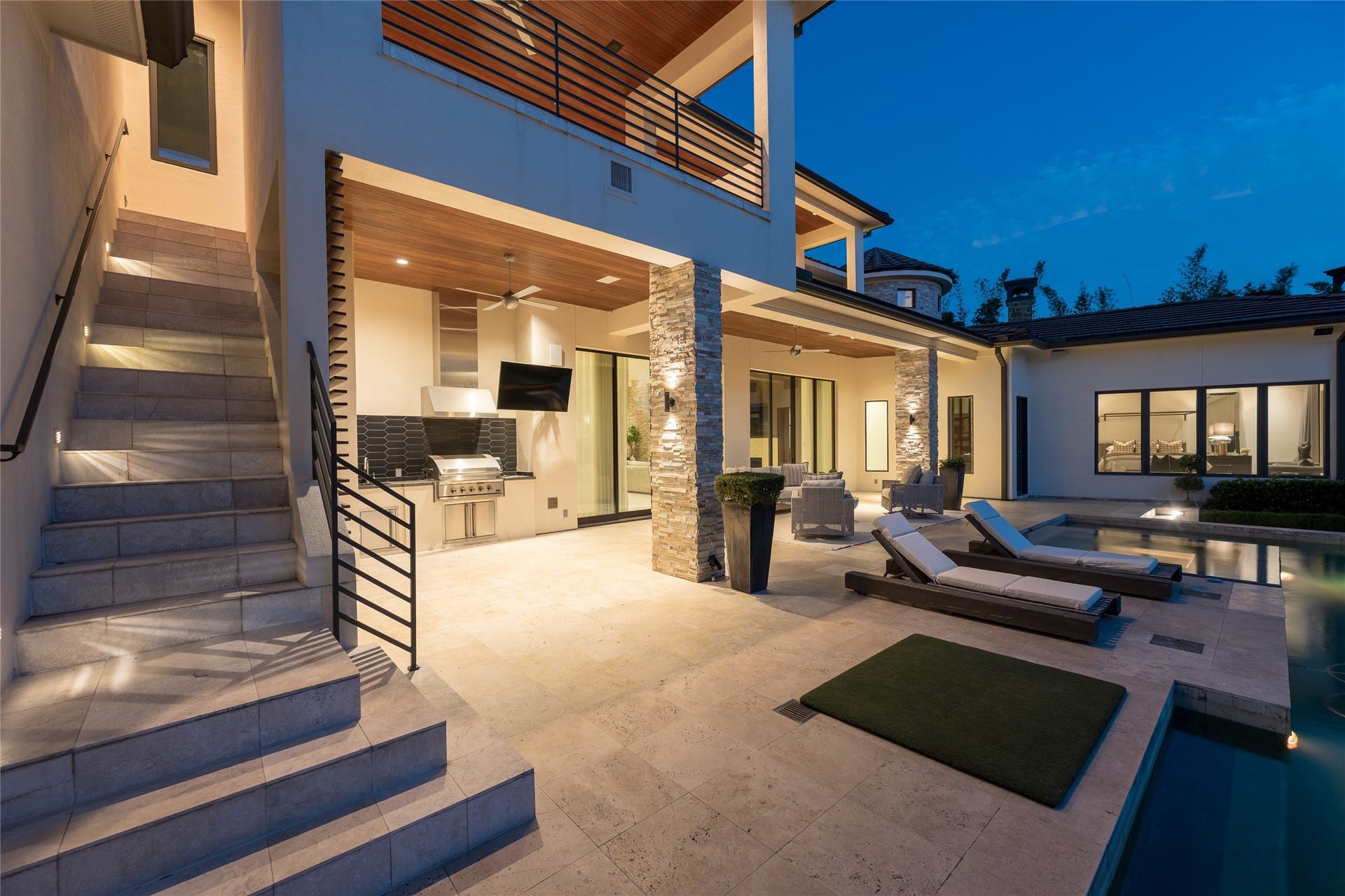 309 Glenwood Drive, Houston, TX 77007 At dusk, the second covered outdoor living area reveals another layer of the homes entertaining space, with direct access from the main residence and pool. An exterior staircase provides a separate connection to the second floor, while integrated lighting allows the outdoor areas to transition seamlessly into the evening.